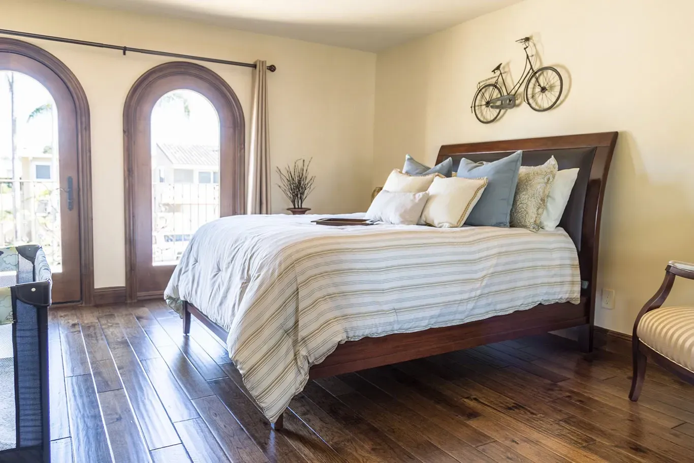 There is a bicycle on the wall above the bed in the bedroom.