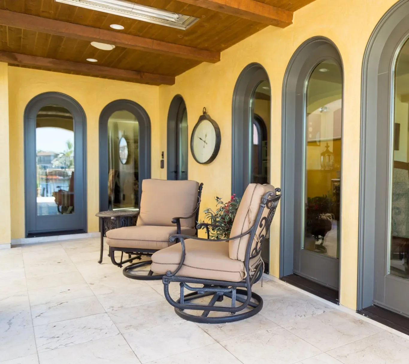 A patio with chairs and a clock on the wall