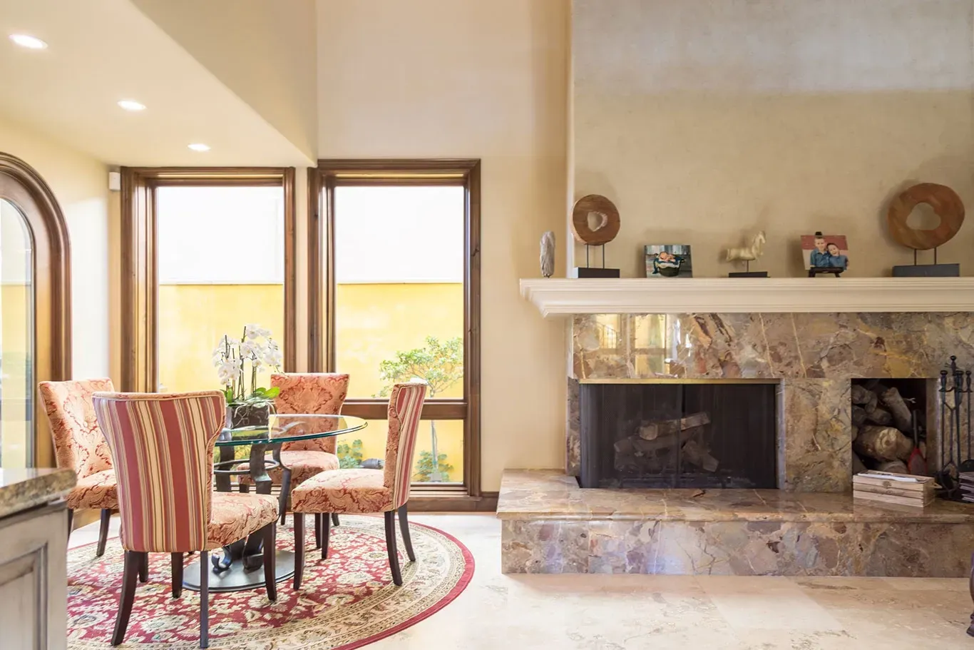 A living room with a fireplace and a table and chairs