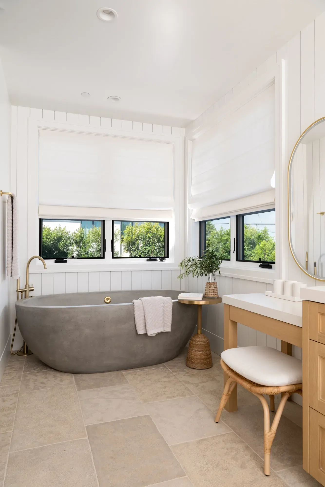A bathroom with a bathtub , sink , mirror and window.