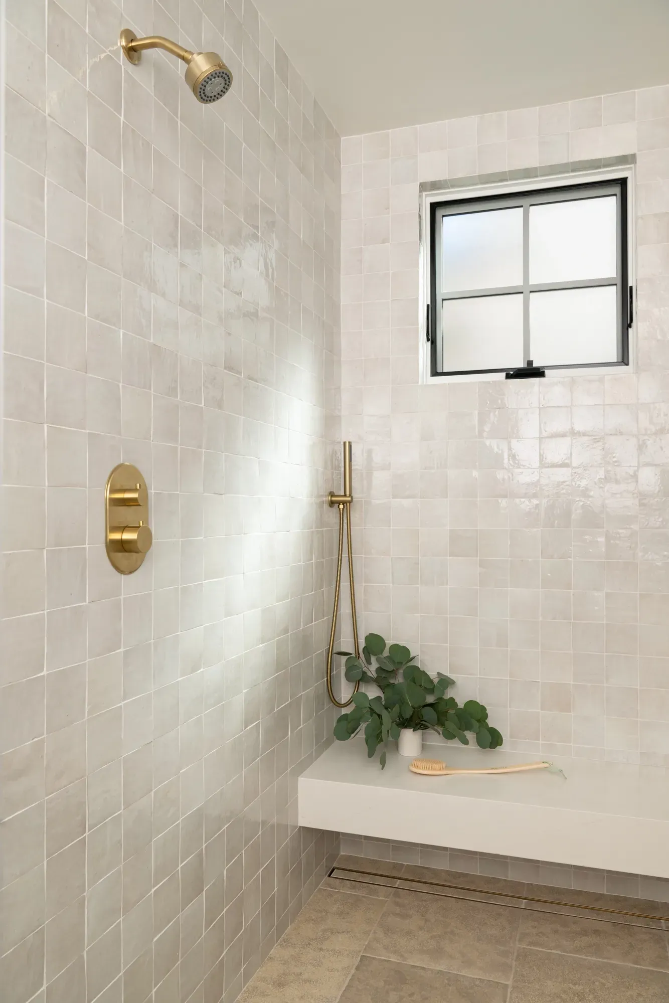 A bathroom with a walk in shower and a window.