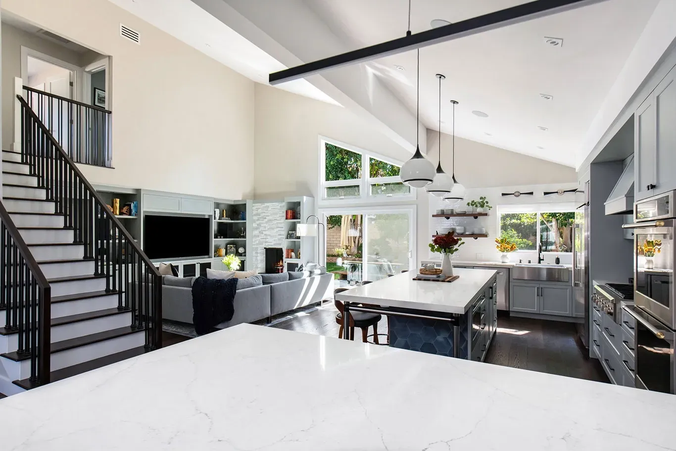 A kitchen with a large island and stairs leading up to the second floor.