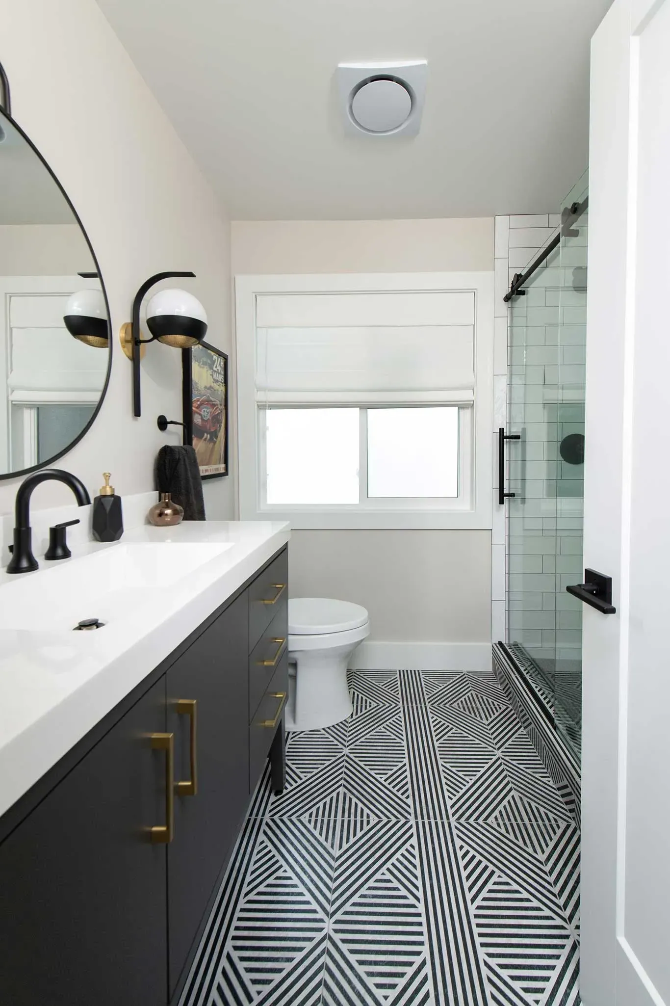 A bathroom with a toilet , sink , mirror and shower.