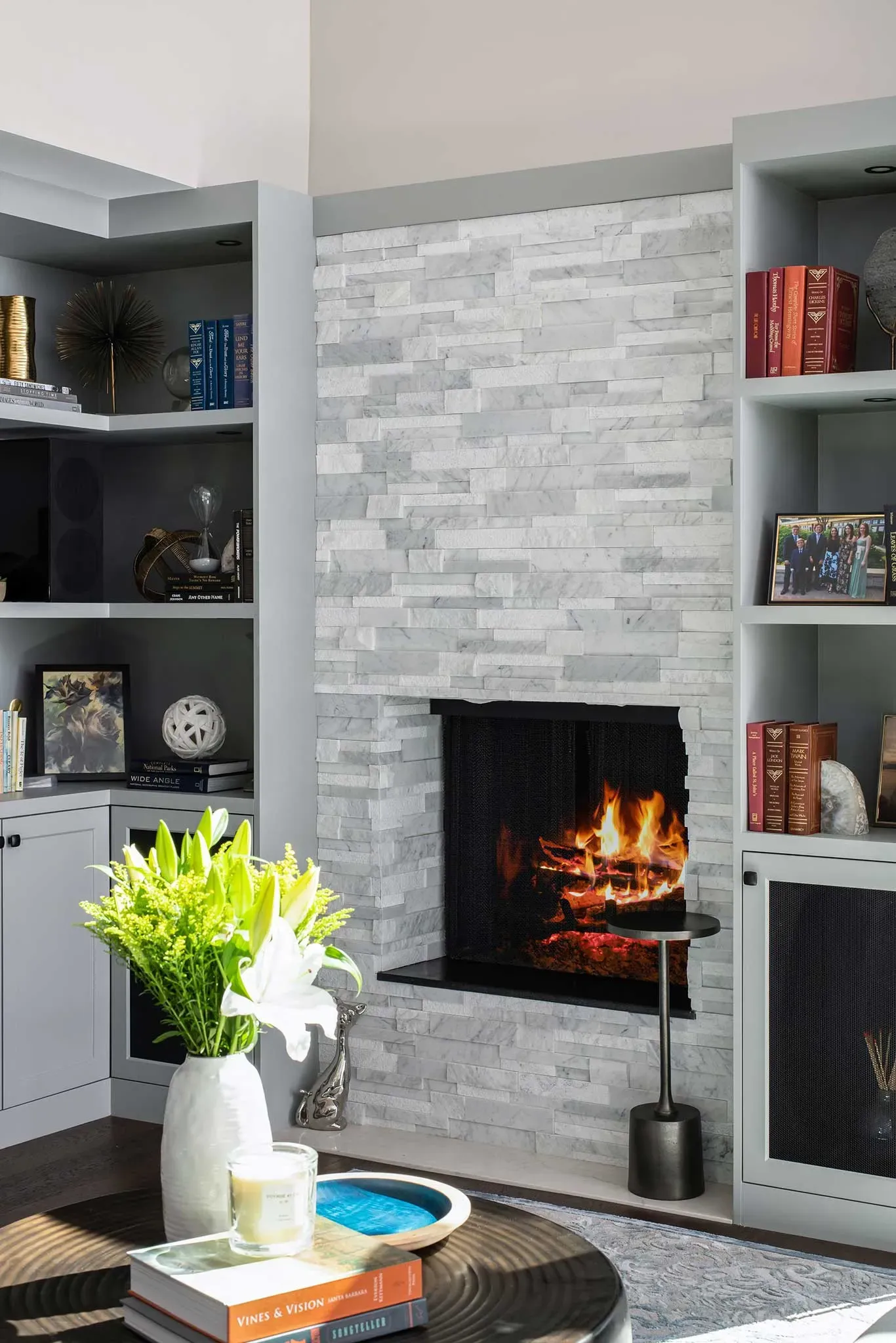 A living room with a fireplace and bookshelves