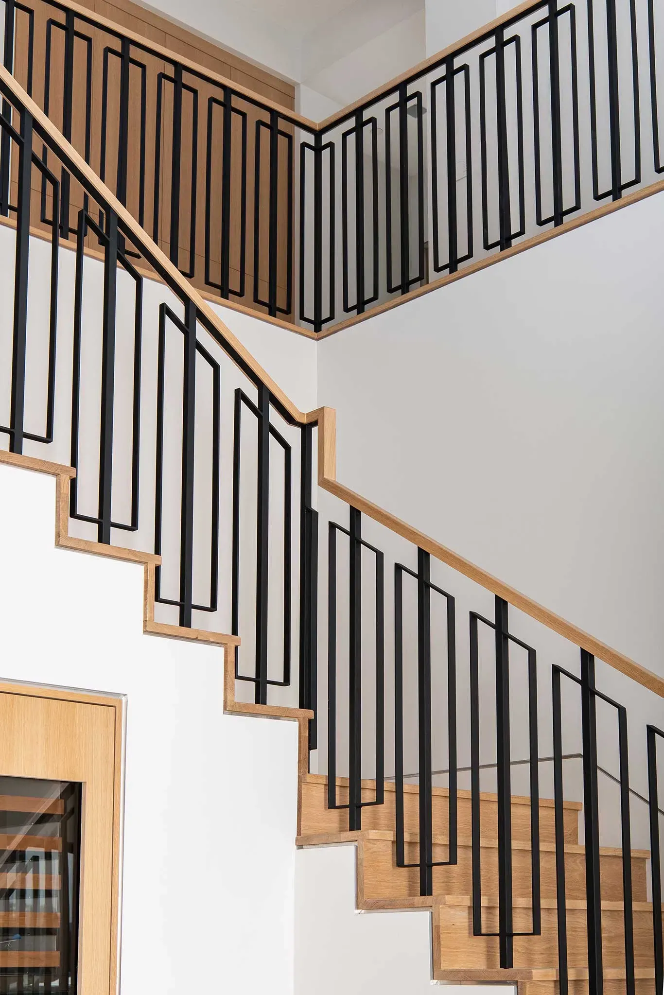 A staircase with a black railing and wooden steps in a house.