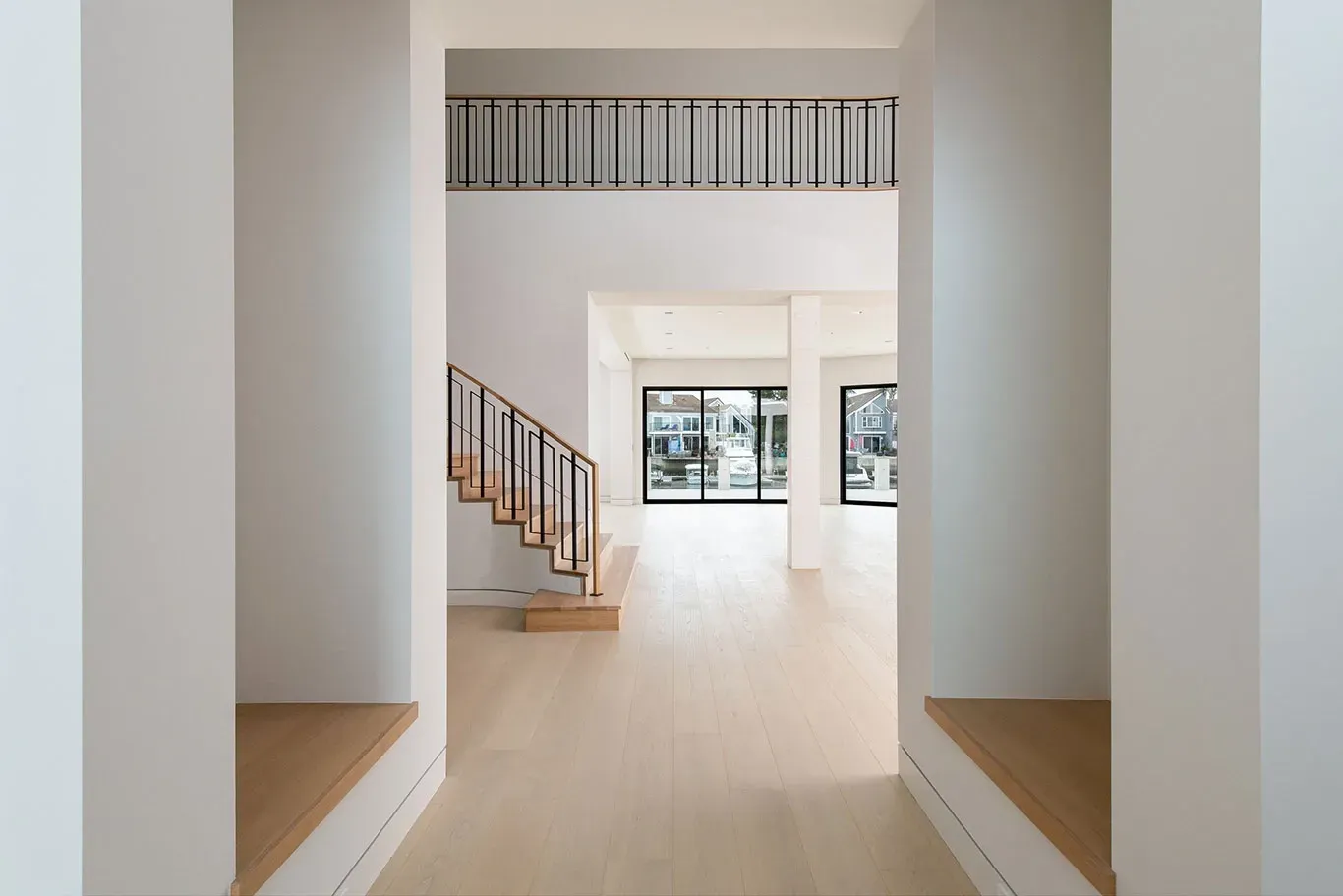 A hallway leading to a staircase in an empty house
