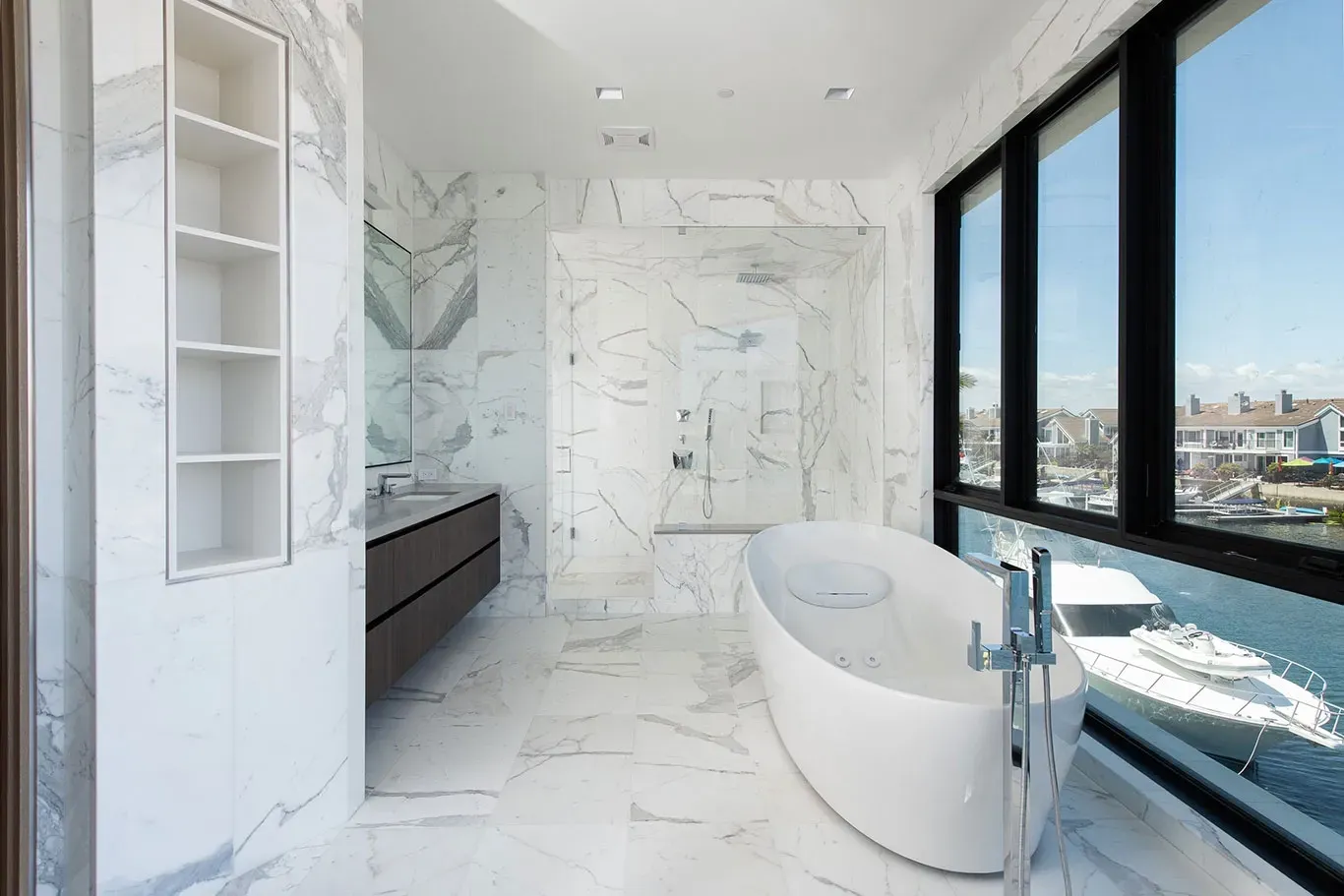 A bathroom with a bathtub and a large window overlooking the water.