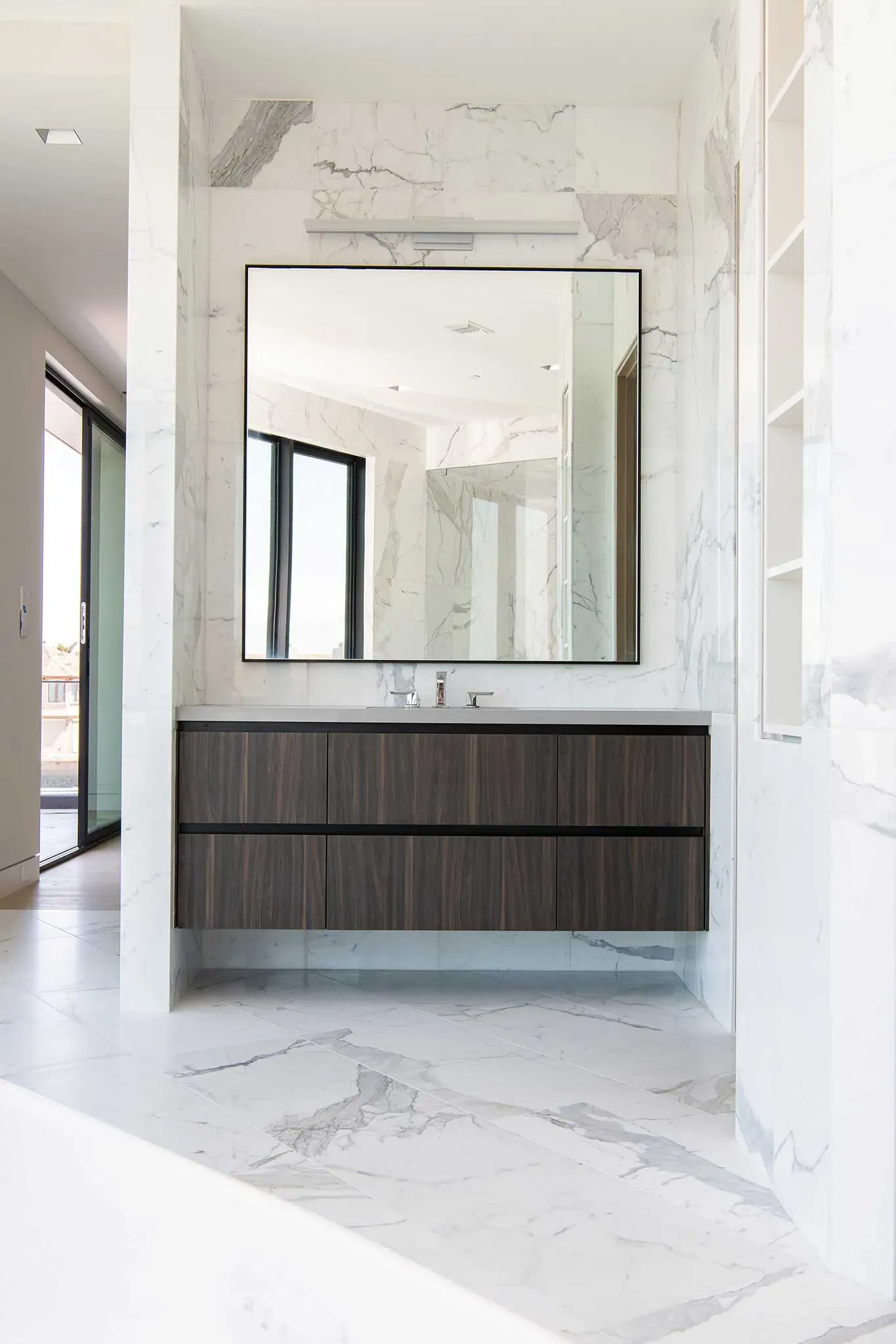 A bathroom with a large mirror and a sink.