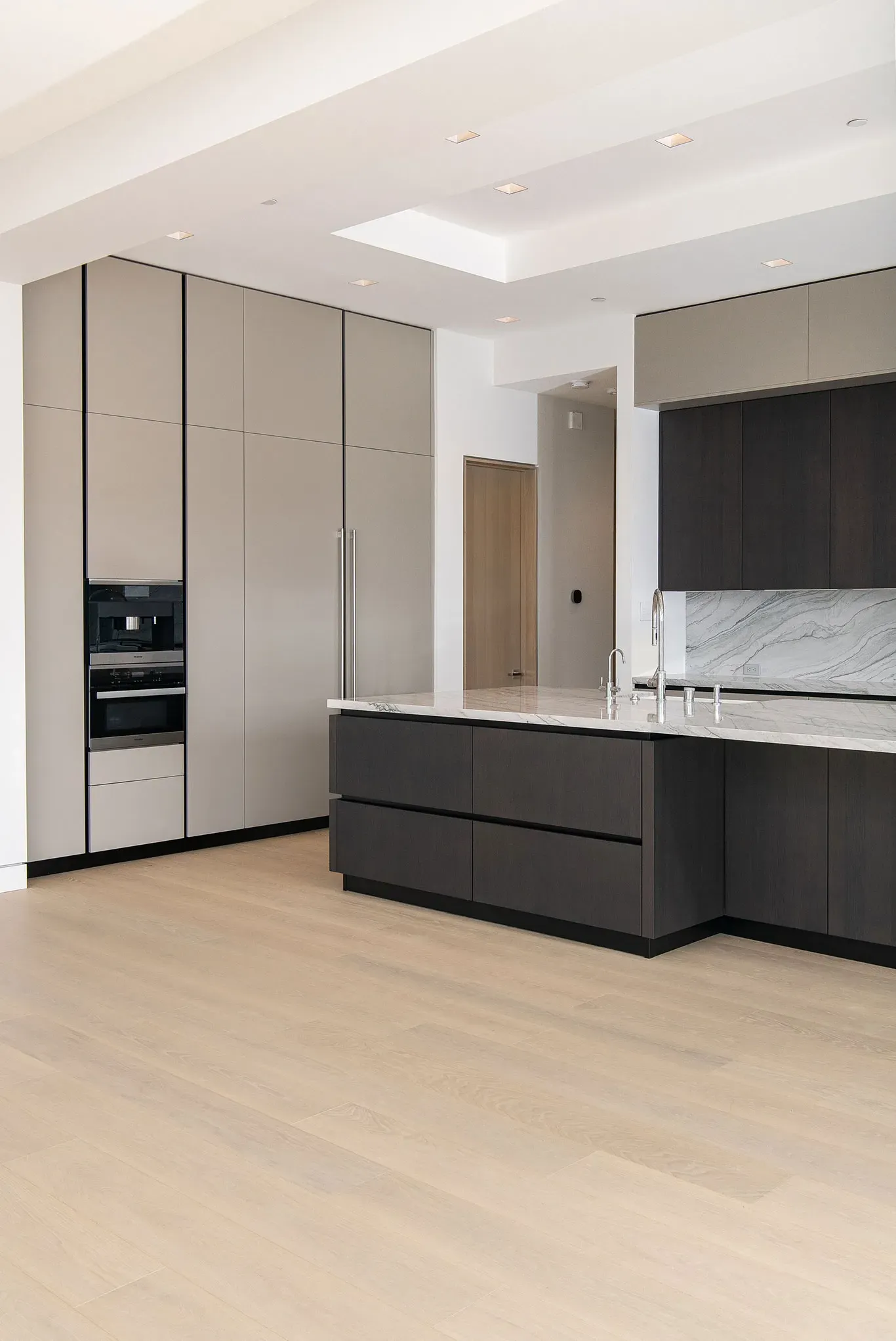 A kitchen with black cabinets and a large island in the middle.