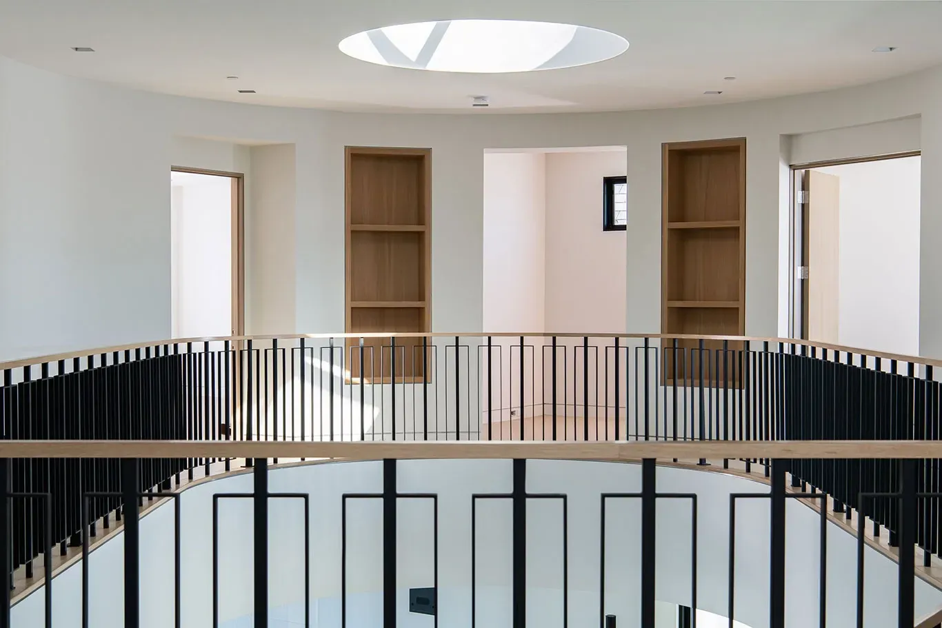 An empty room with a railing and a skylight in the ceiling.