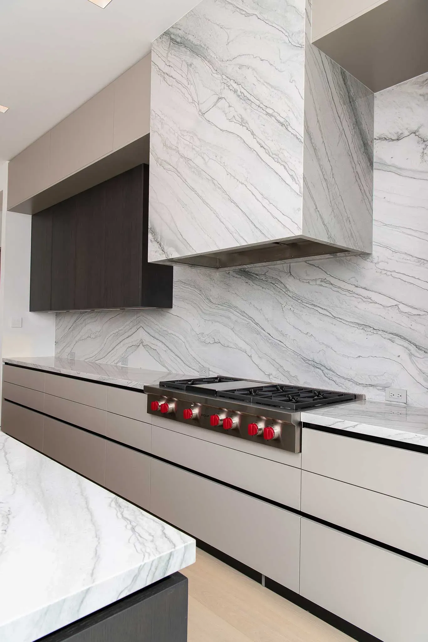 A kitchen with a stove top oven and marble counter tops