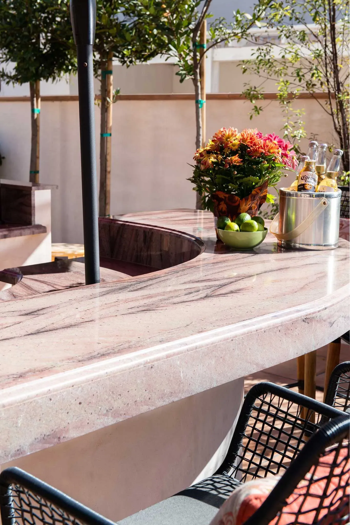 A table with a bowl of fruit and flowers on it
