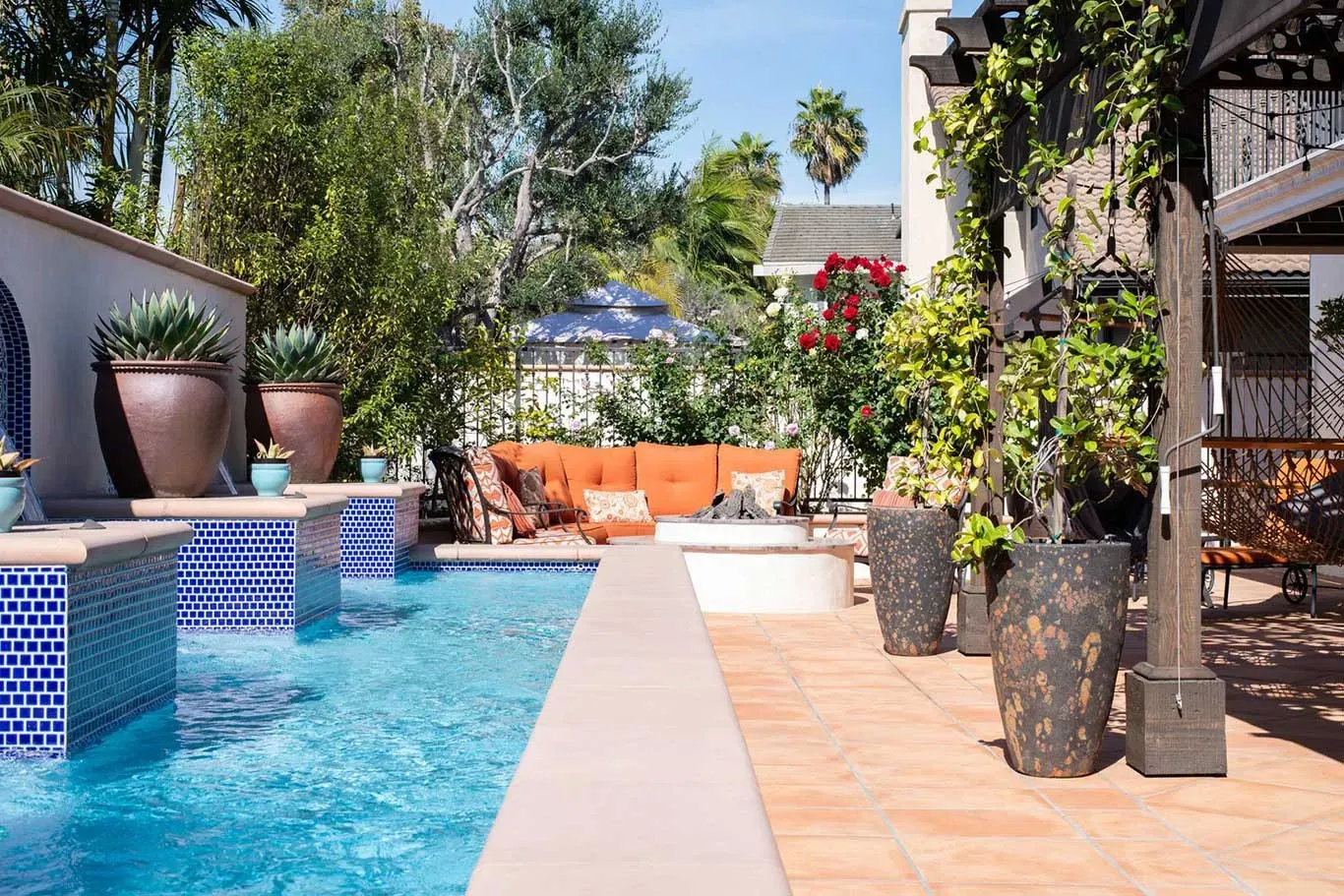 There is a large swimming pool in the backyard of a house.