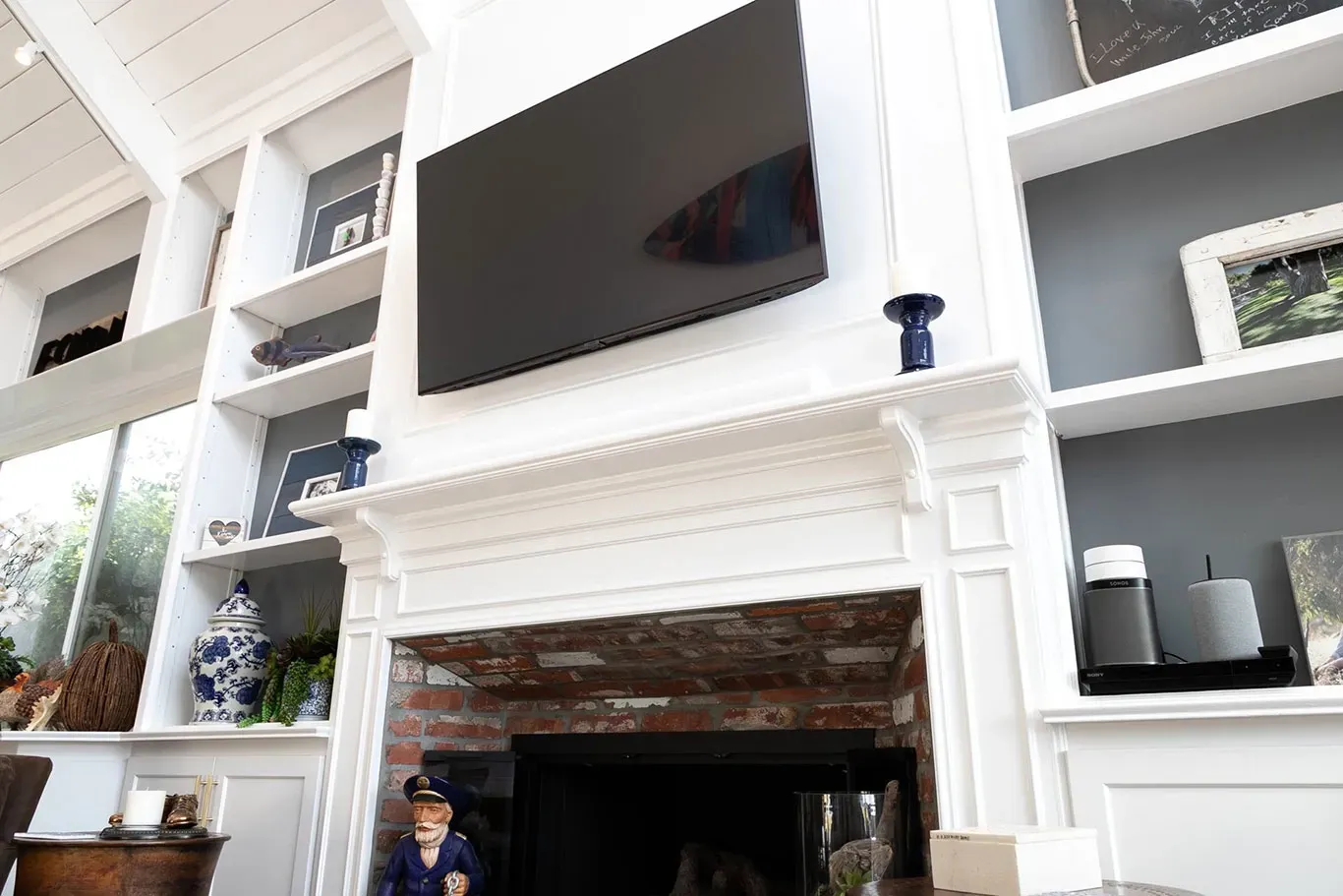 A living room with a fireplace and a flat screen tv on the wall.