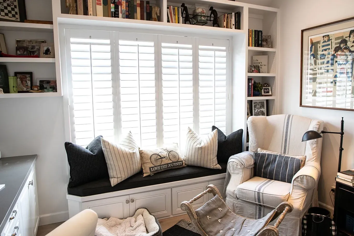 A living room with a window seat and a chair.