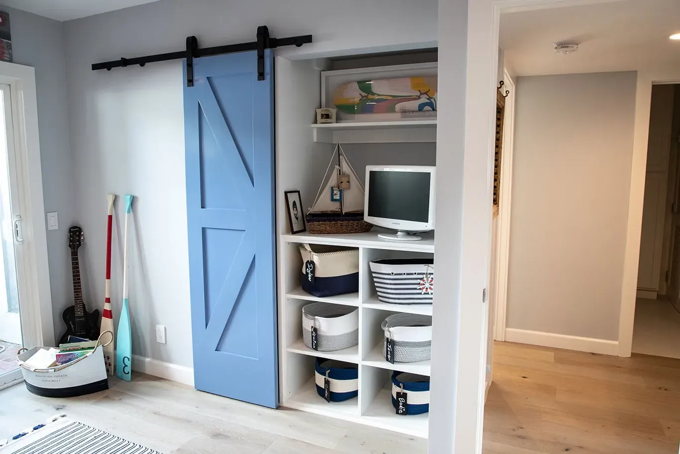 A room with a blue sliding barn door and shelves.