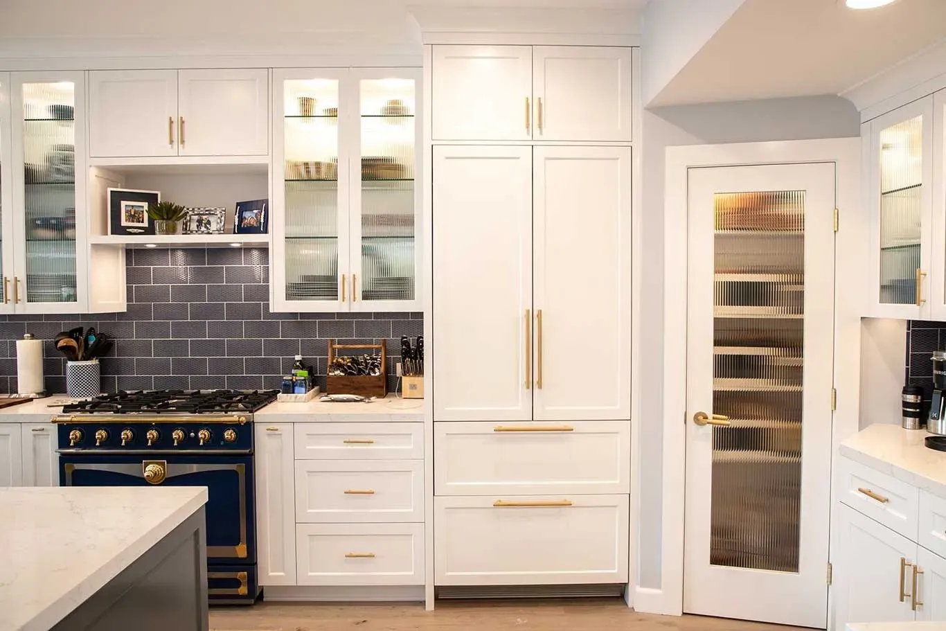A kitchen with white cabinets and a blue stove top oven.