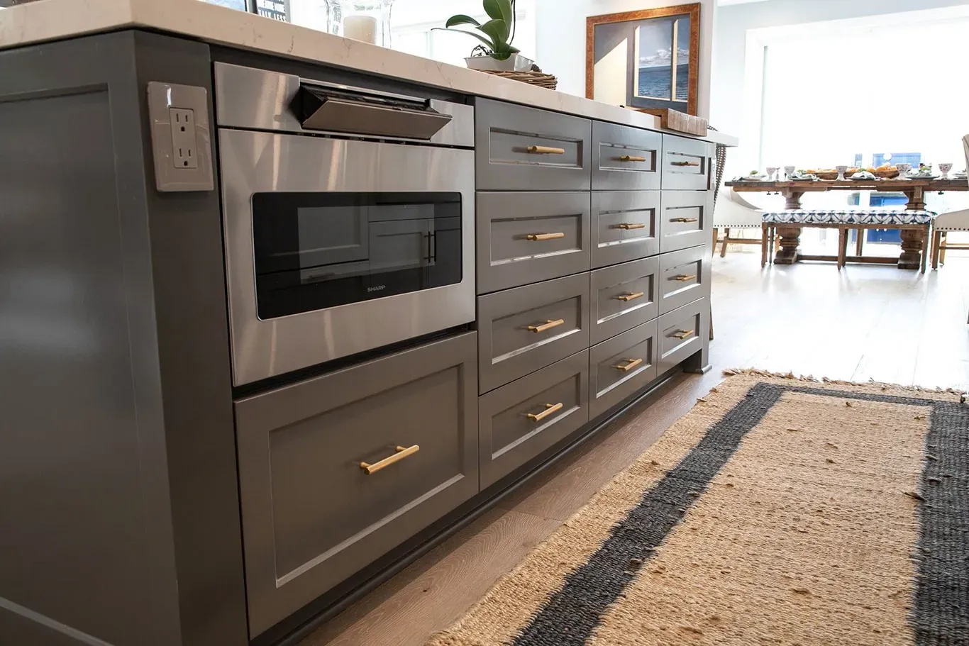 A kitchen with stainless steel appliances and gray cabinets.