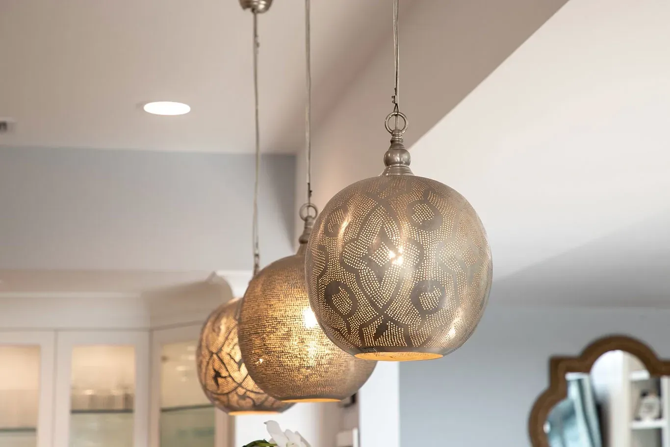 Three pendant lights are hanging from the ceiling in a kitchen