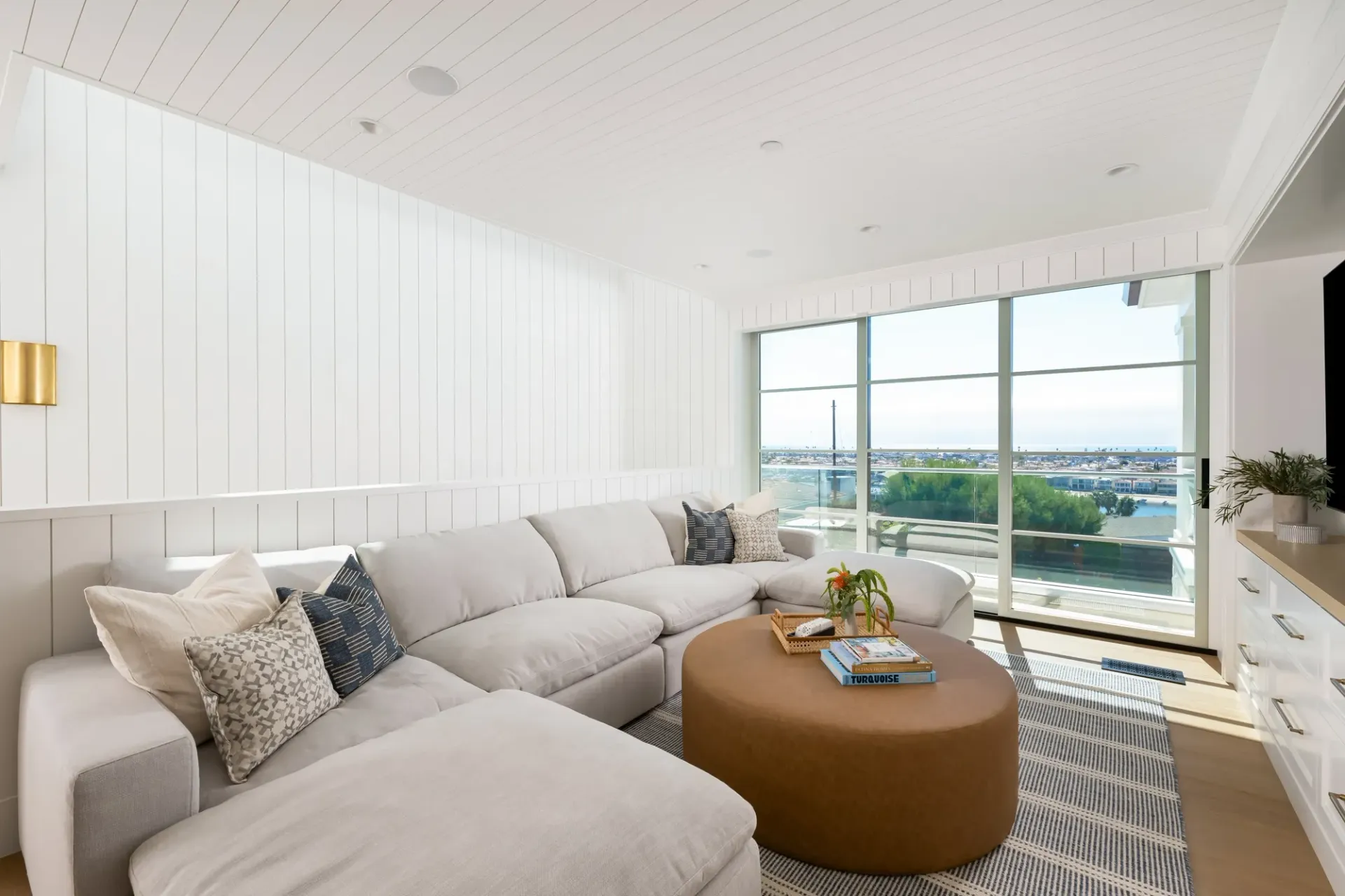 A living room with a large sectional couch and a round coffee table.