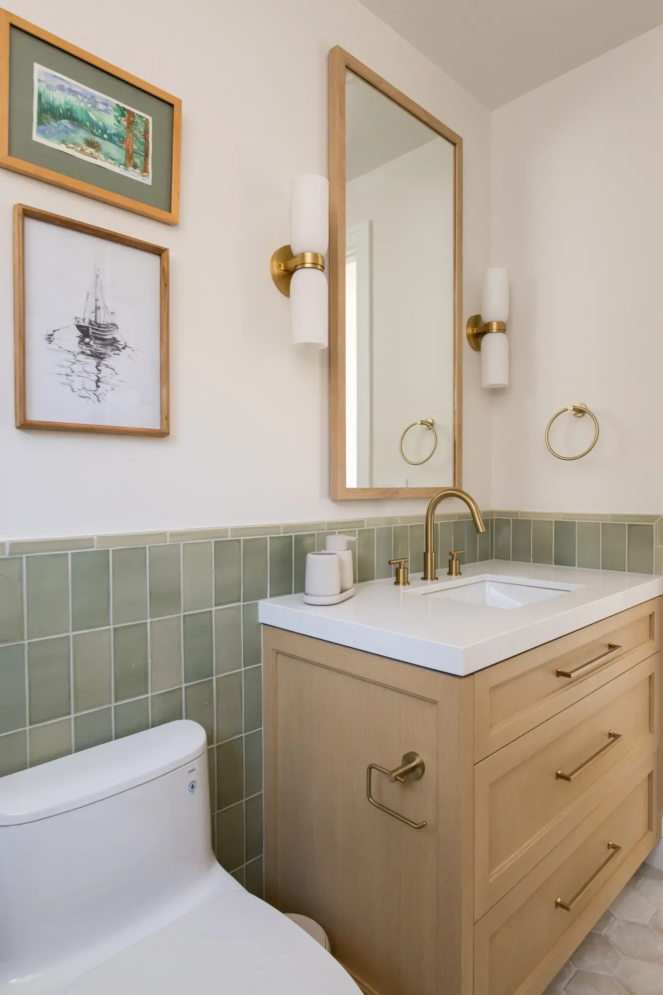 A bathroom with a toilet , sink and mirror.