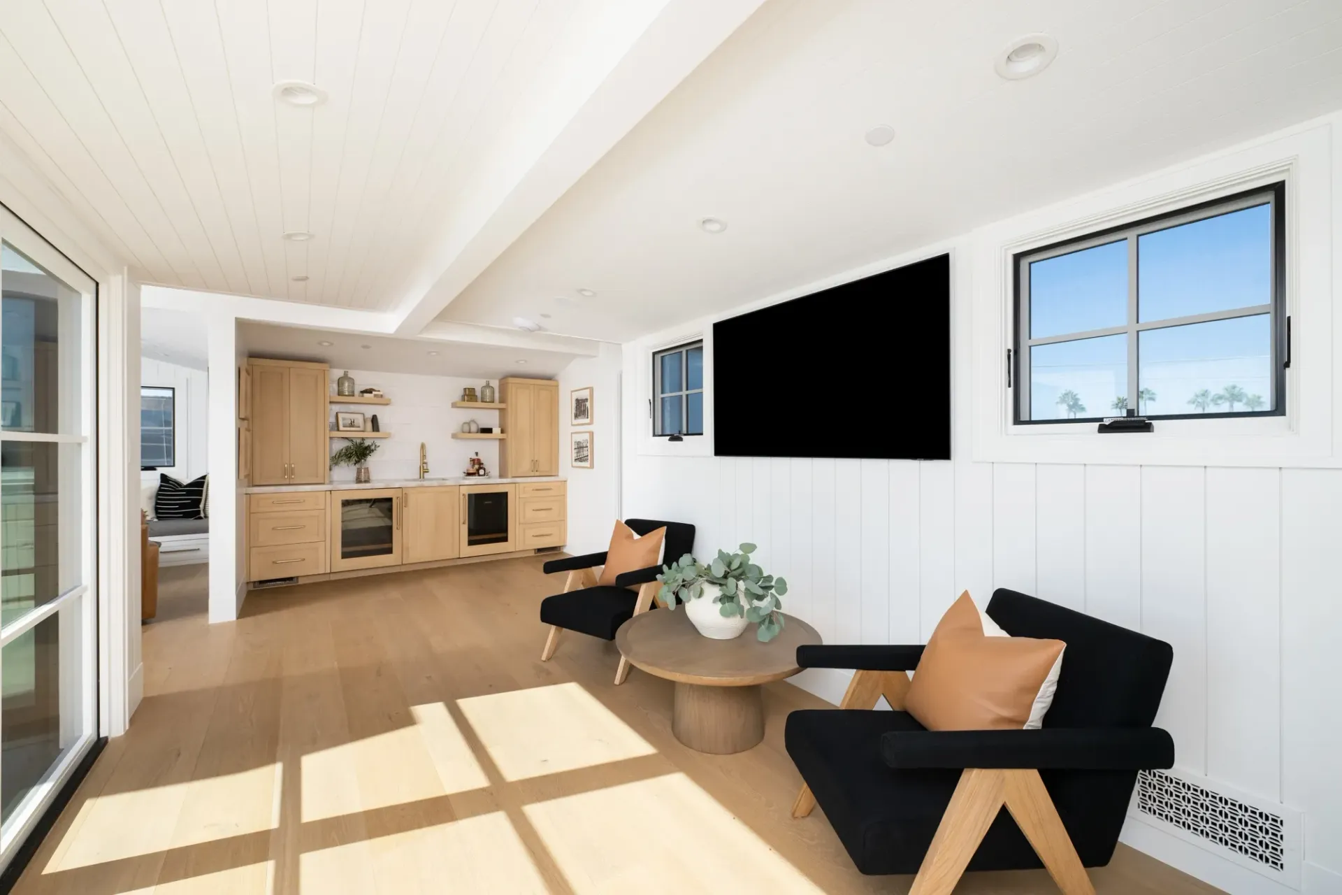 A living room with chairs , a table and a flat screen tv.