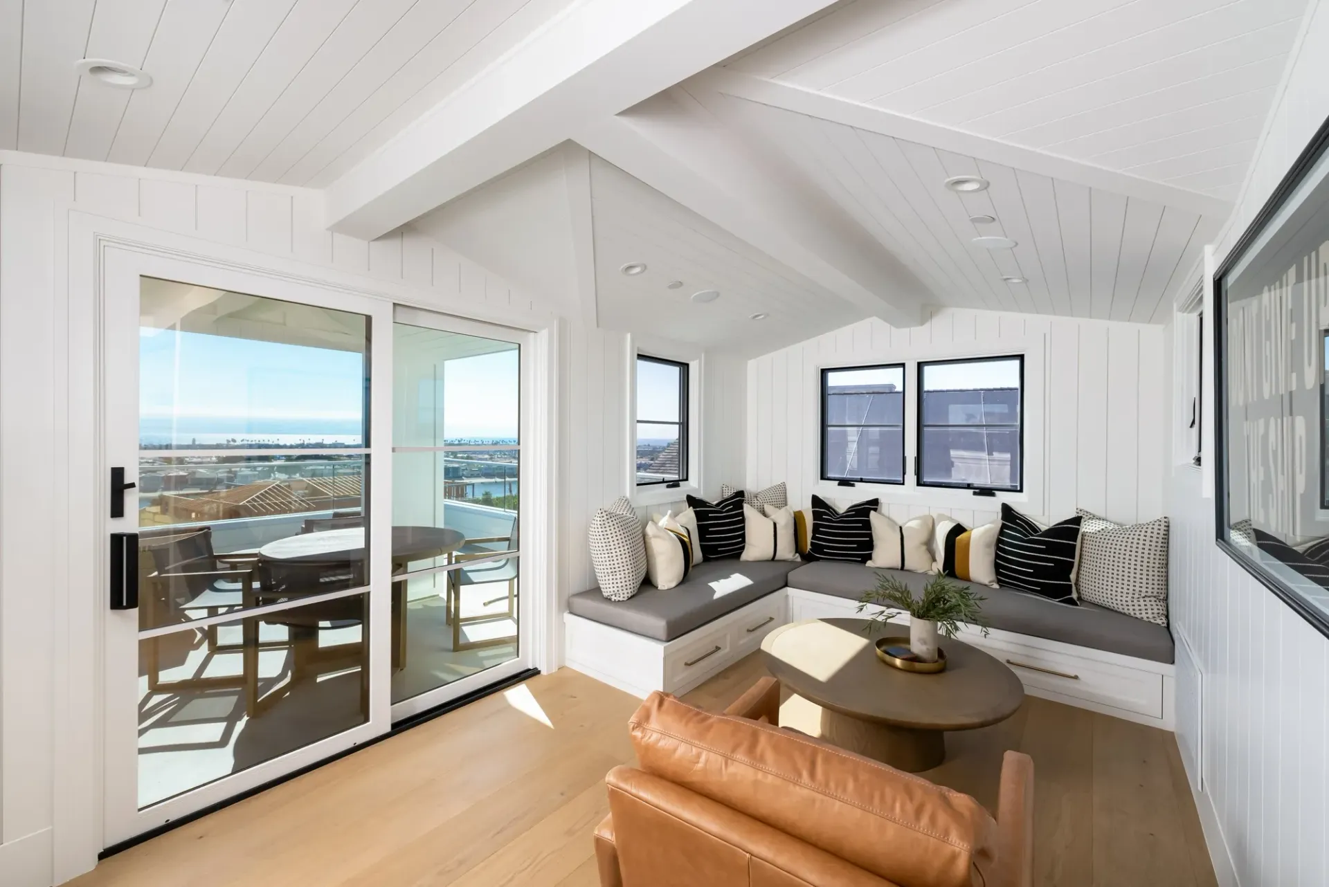 A living room with a couch , chair , coffee table and sliding glass doors.