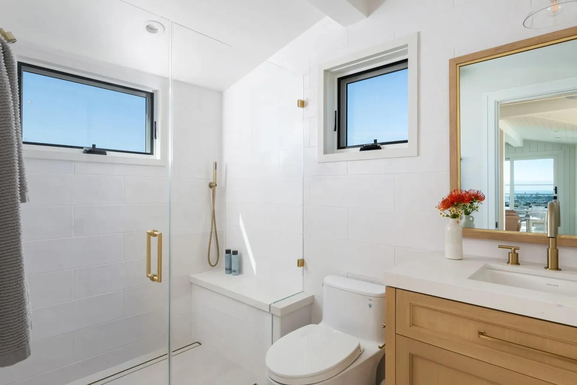 A bathroom with a toilet , sink , shower and mirror.