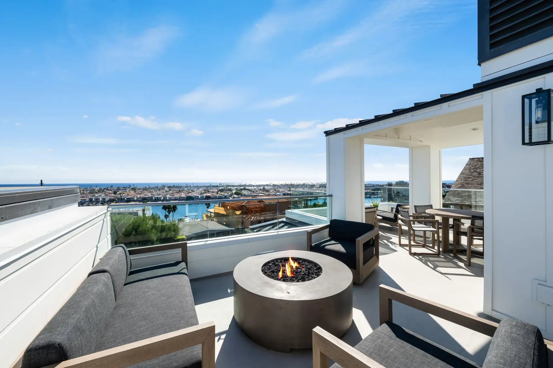 There is a fire pit on the patio with a view of the ocean.