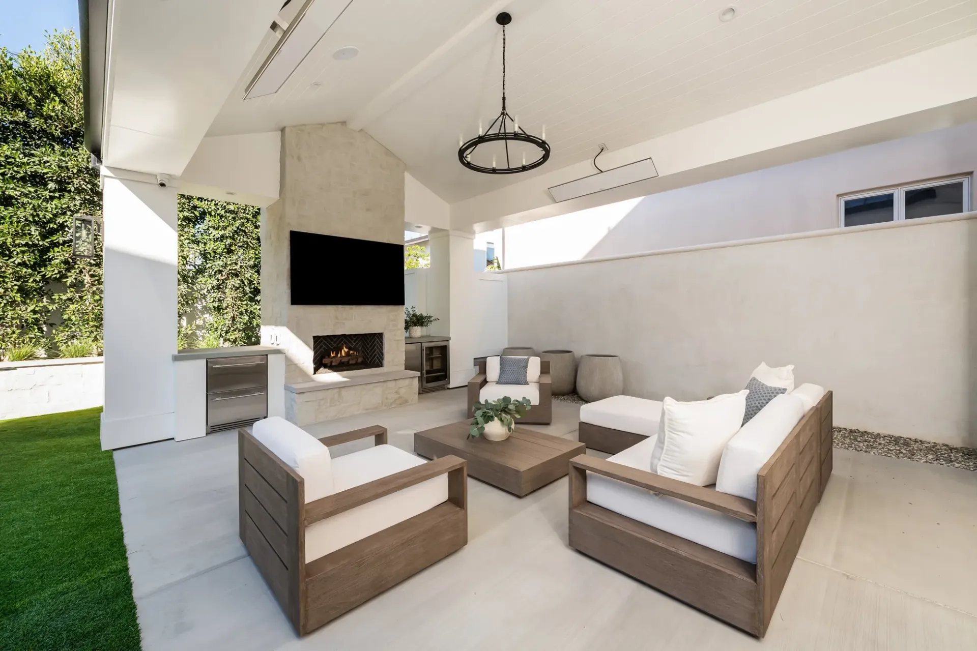A patio with a couch , chairs , table and television.