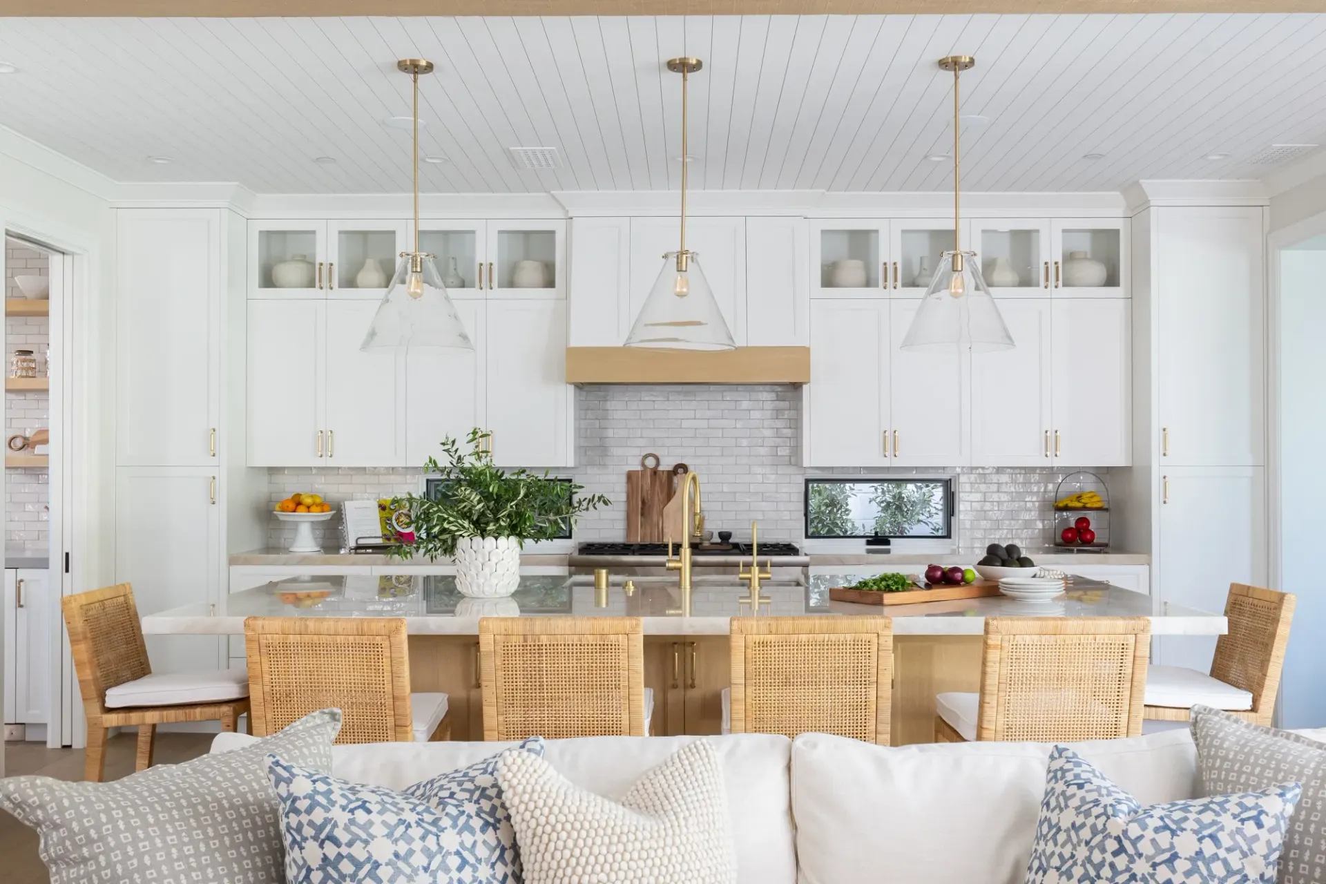 A living room with a couch , chairs , and a kitchen.