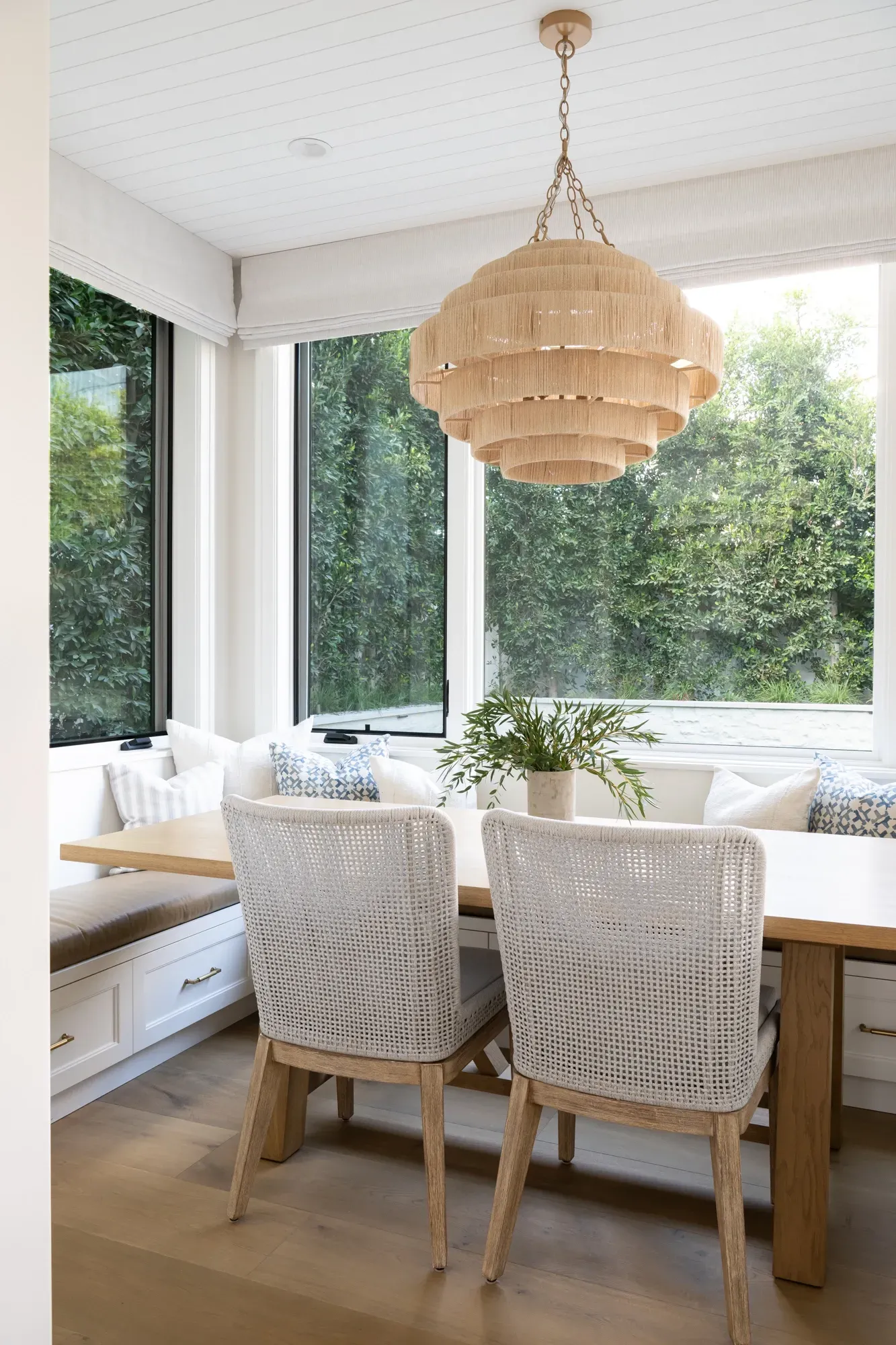 A dining room with a table and chairs and a chandelier hanging from the ceiling.