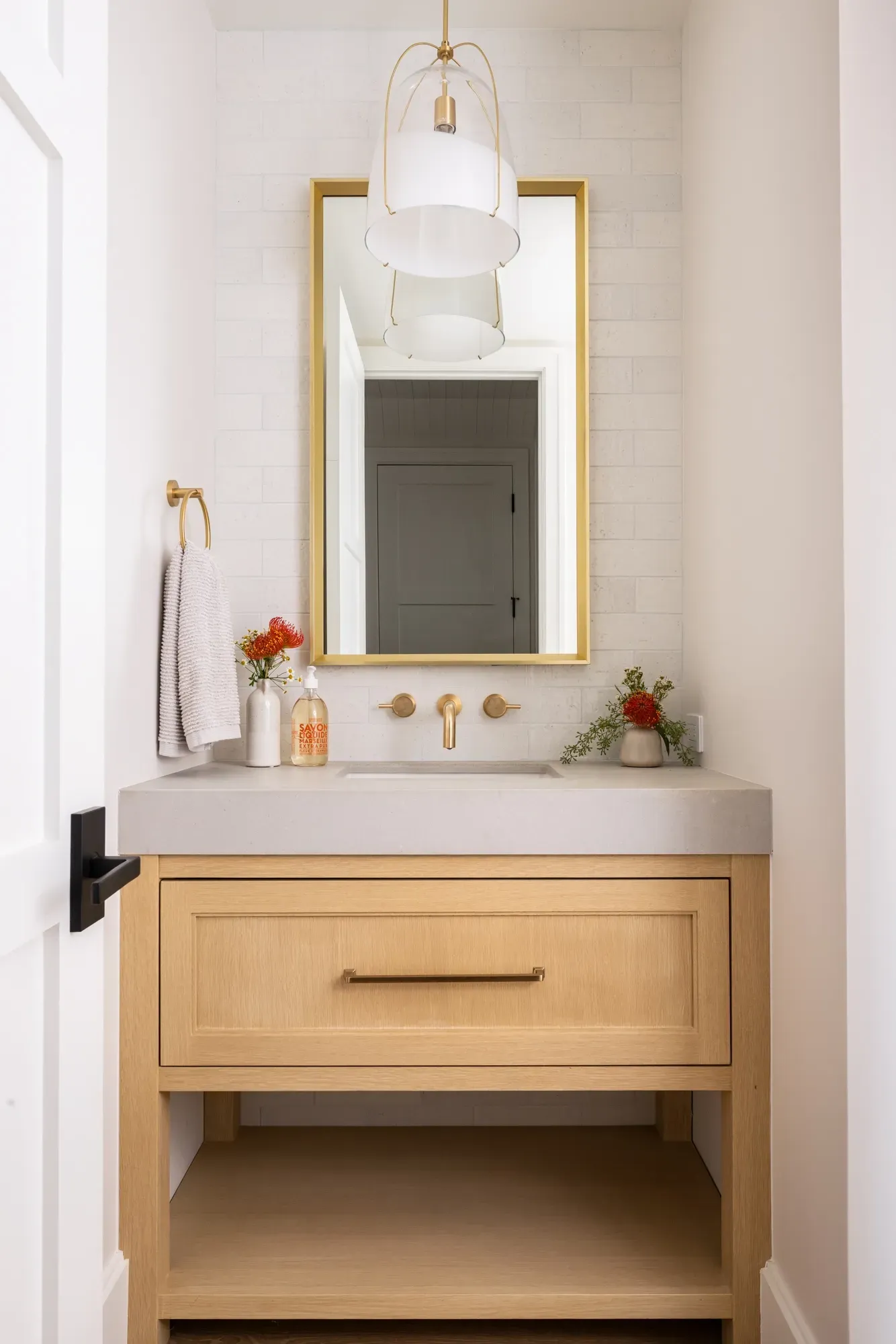 A bathroom with a wooden vanity and a mirror.