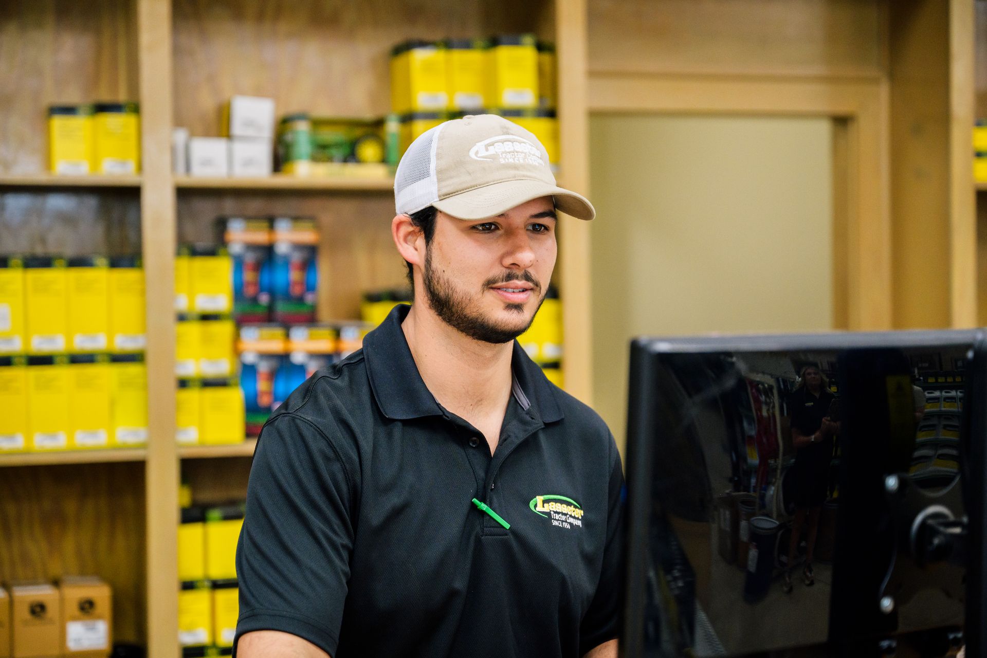 A man is standing in front of a computer in a store.