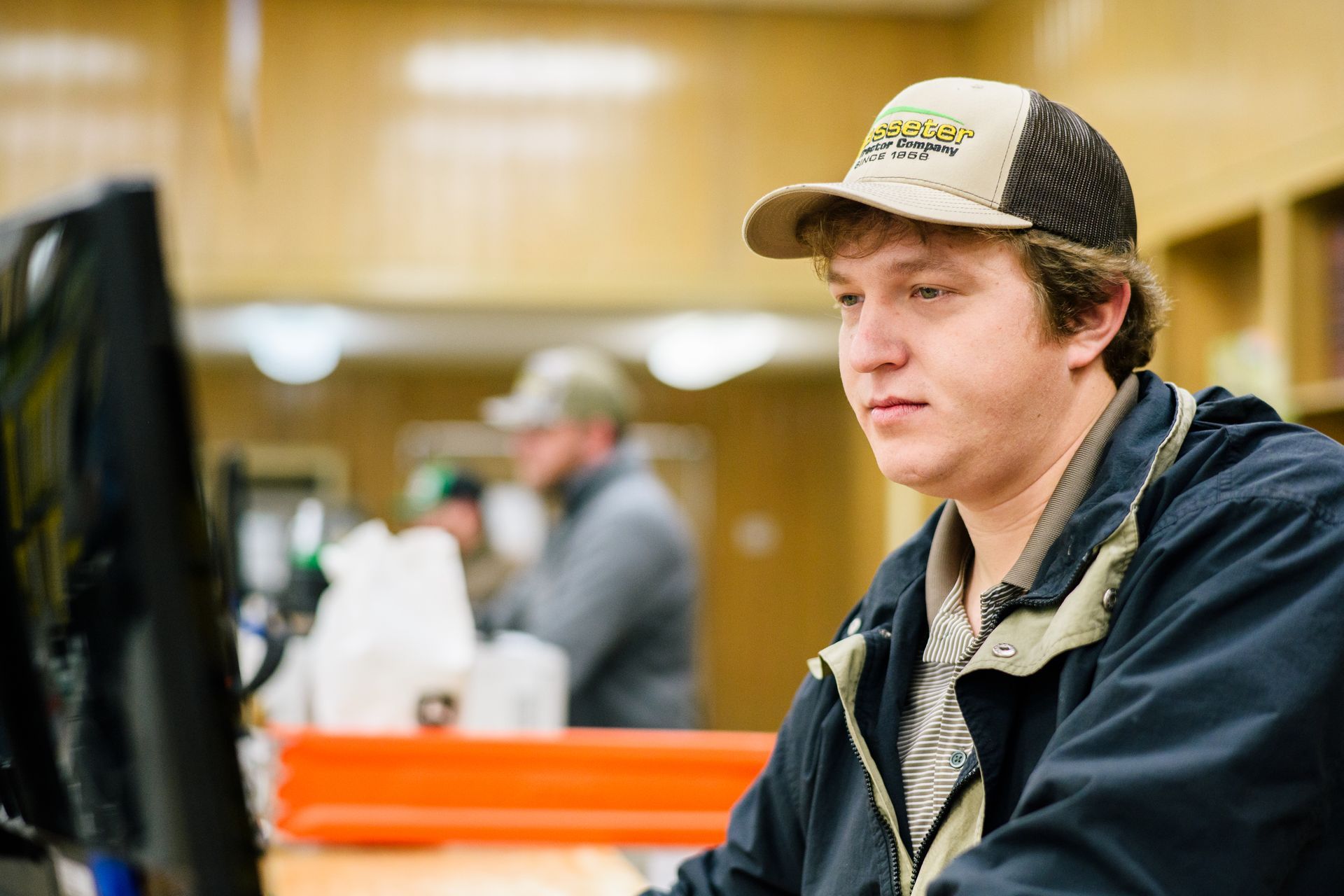 A man is standing in front of a computer in a store.