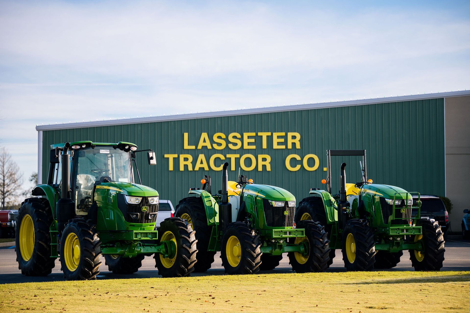 A row of green and yellow John Deere tractors are parked next to each other.