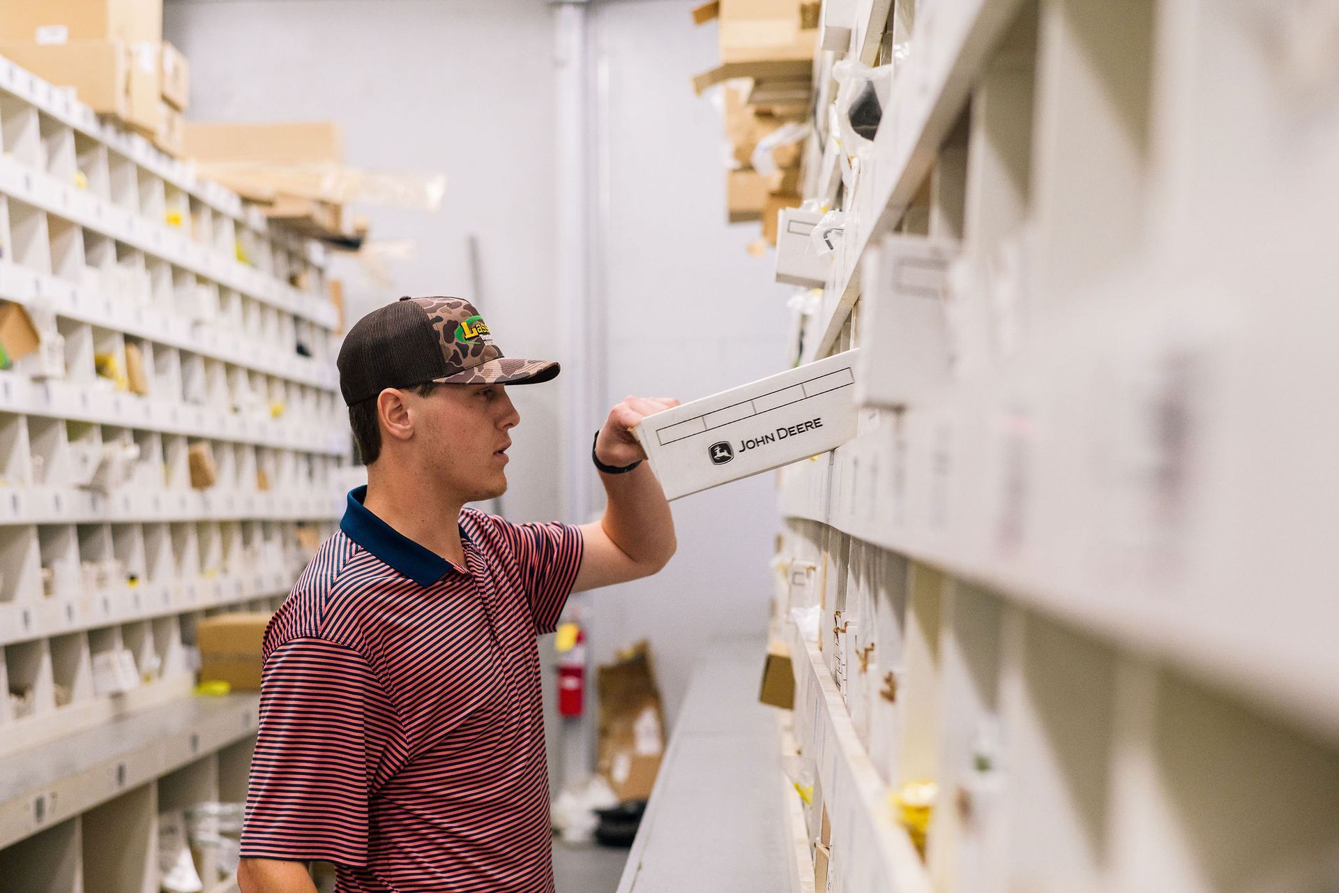A man is standing in a warehouse looking at shelves.