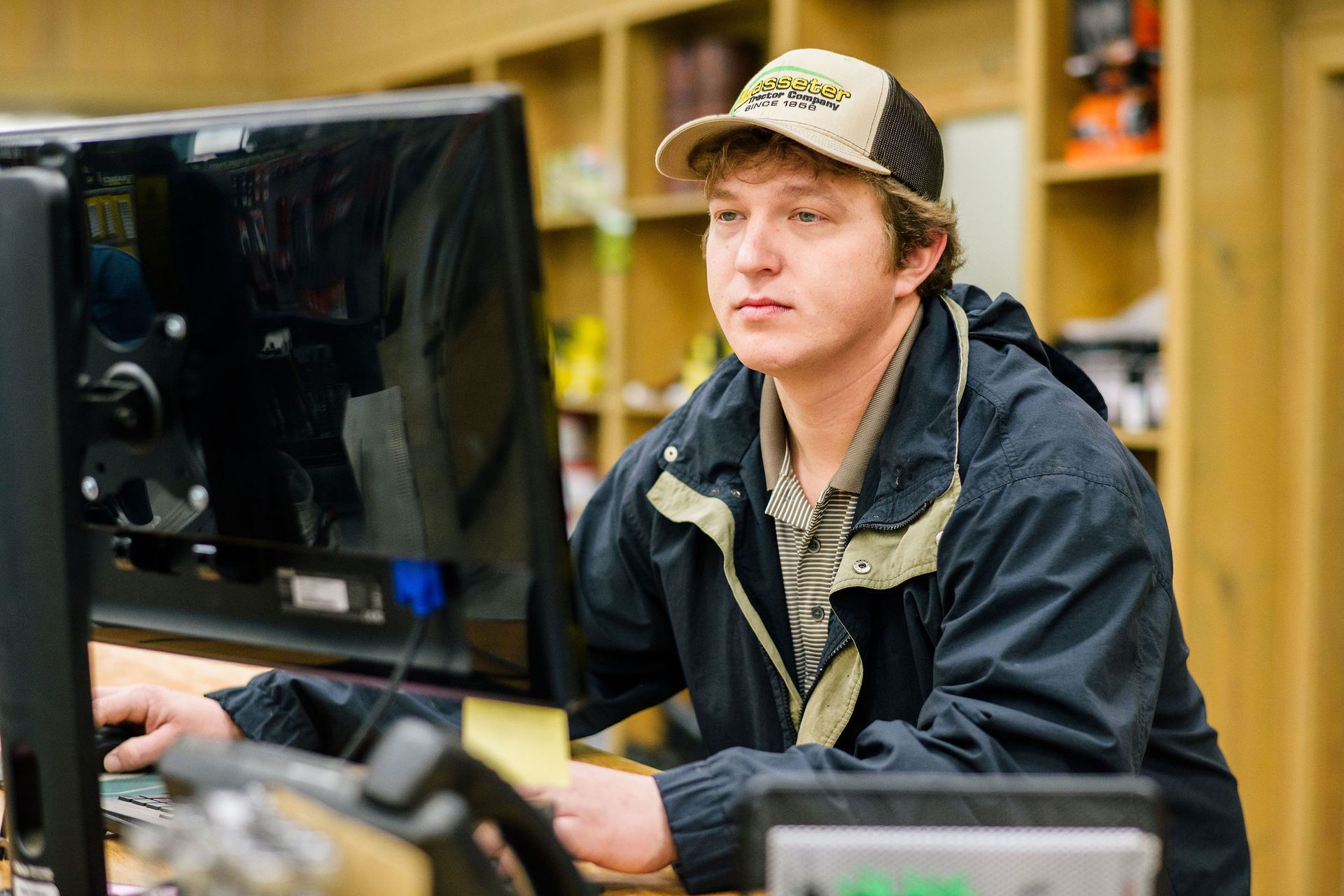 A young man is sitting in front of a computer.