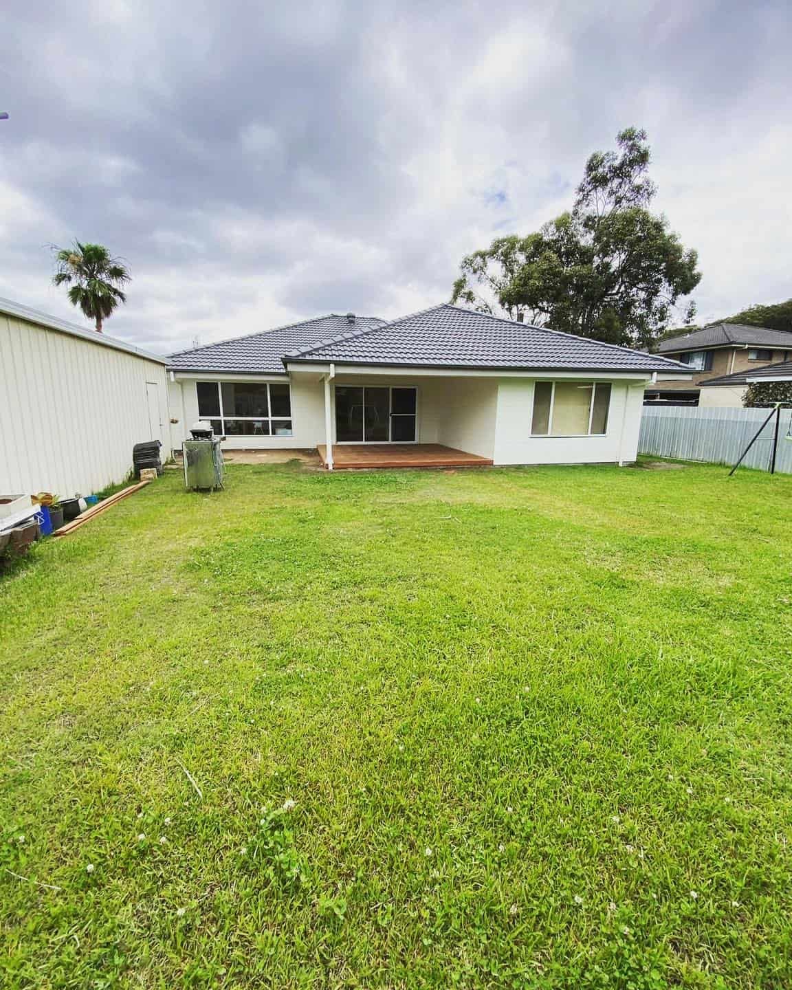 Green Grass In Front Of A White Bungalow House - The Leading Building Company in Cooranbong, NSW