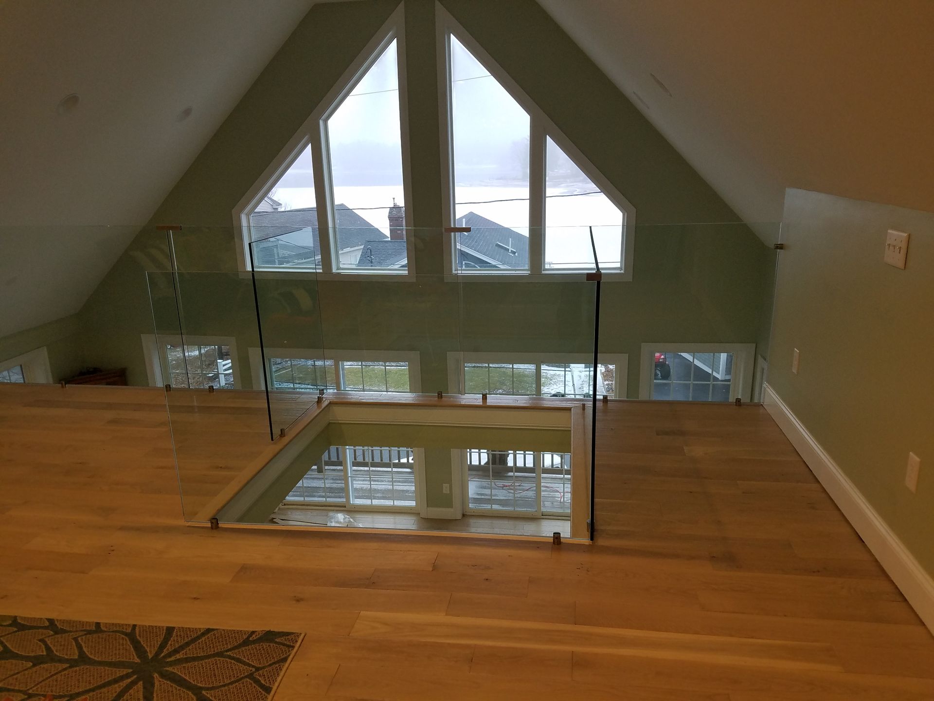 A room with a lot of windows and a glass railing.