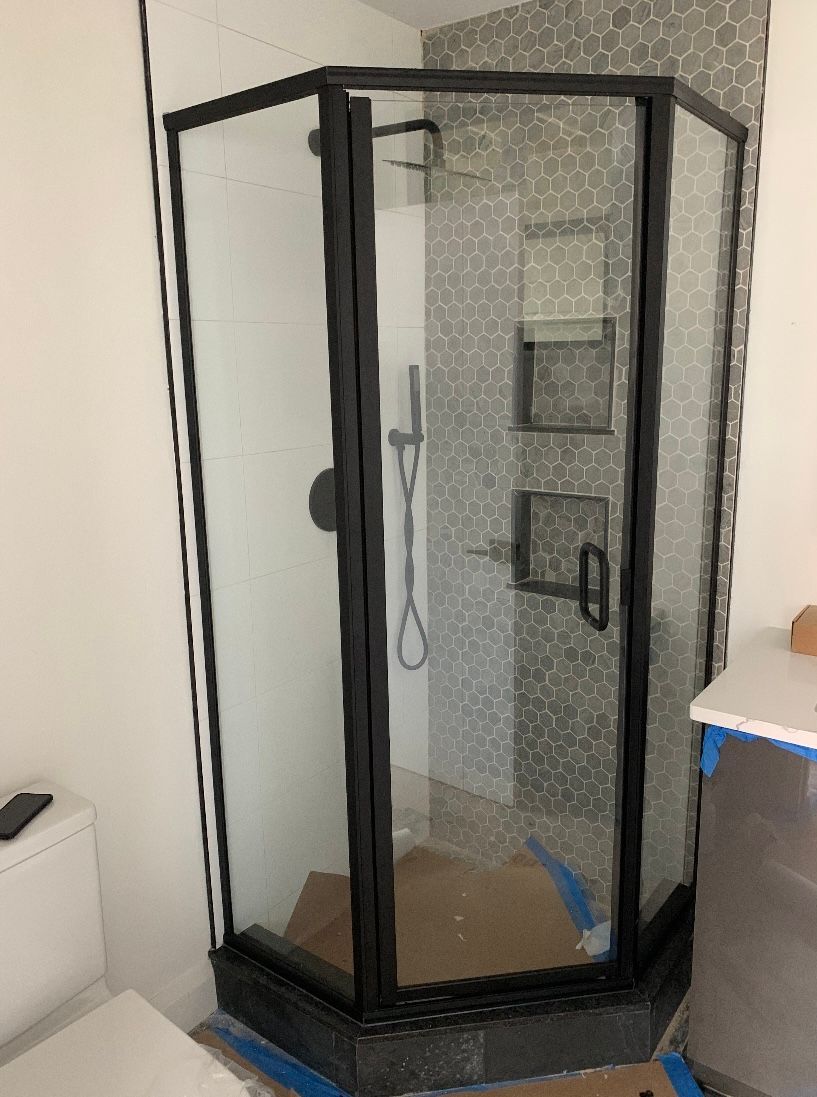 A bathroom with a shower stall and a toilet.