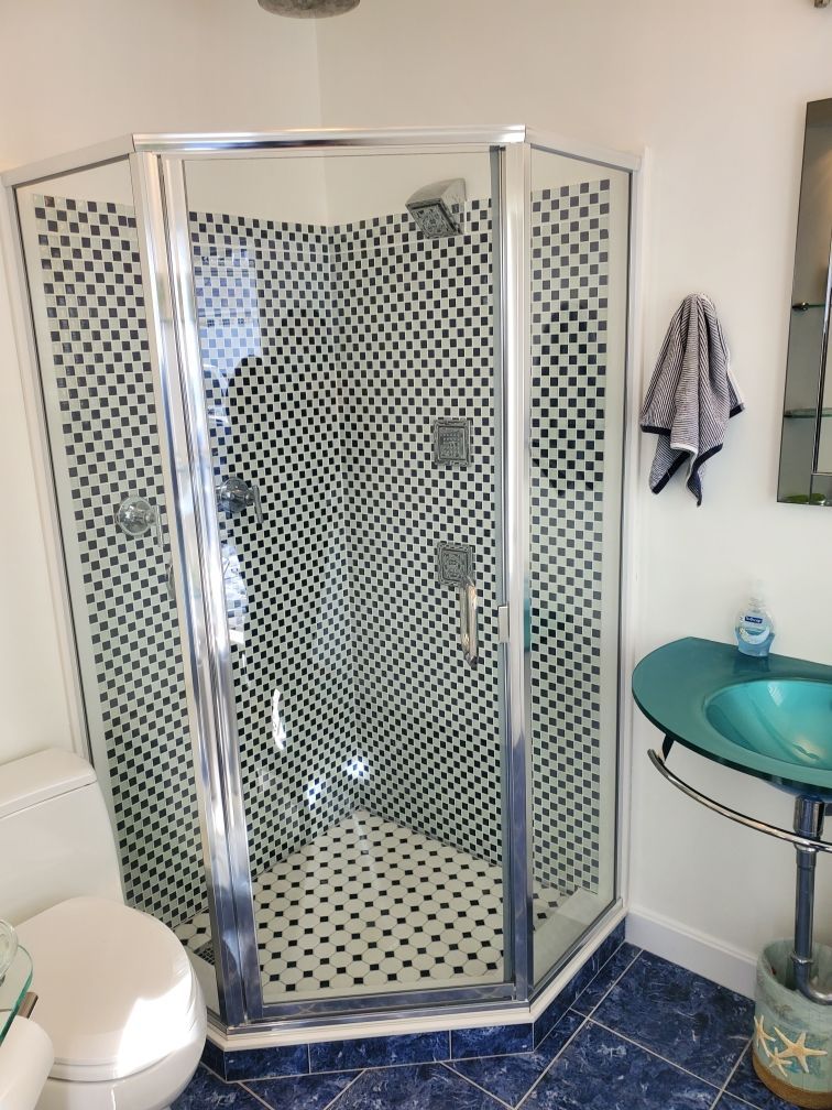 A bathroom with a toilet a sink and a shower stall