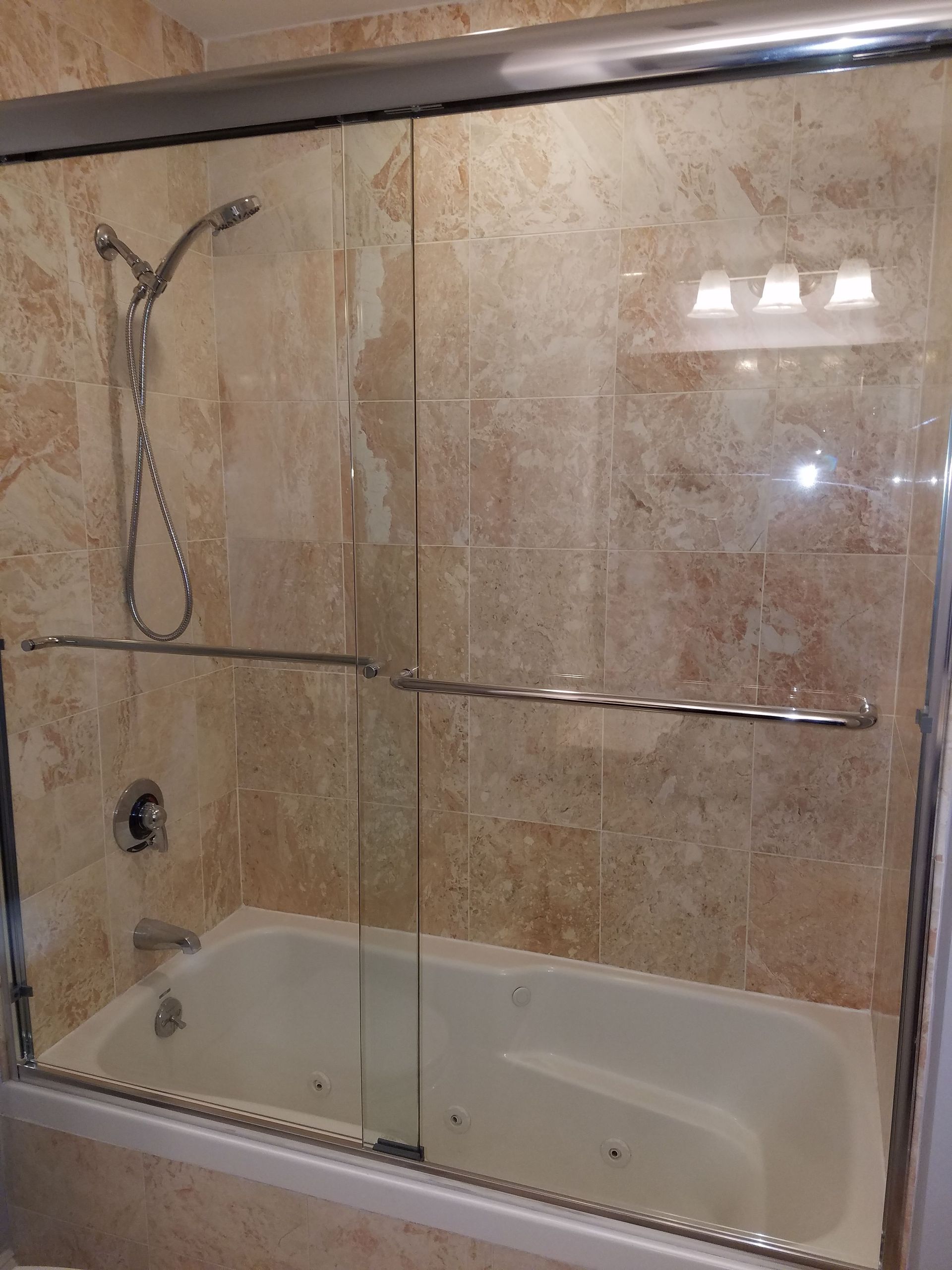 A bathroom with a bathtub and a shower stall with sliding glass doors.