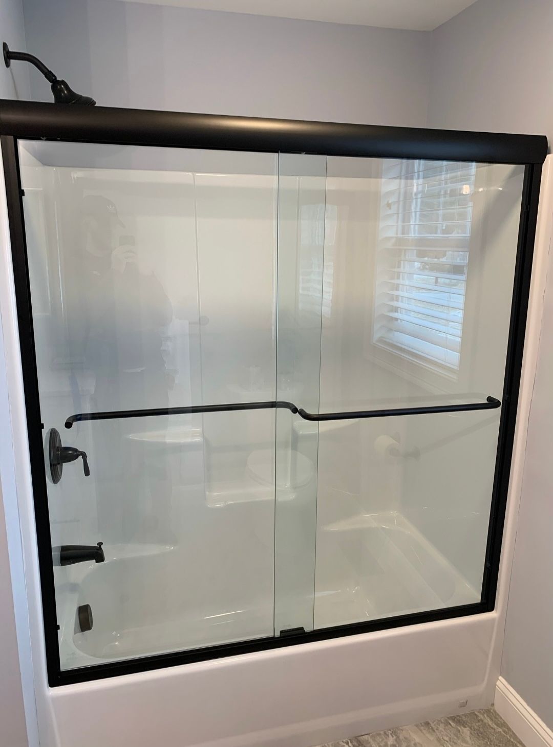 A bathroom with a sliding glass shower door and a bathtub.