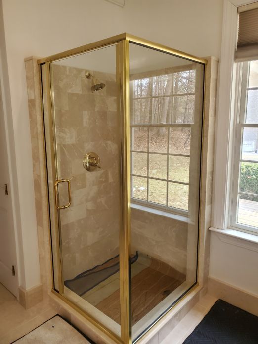 A bathroom with a shower stall and a window