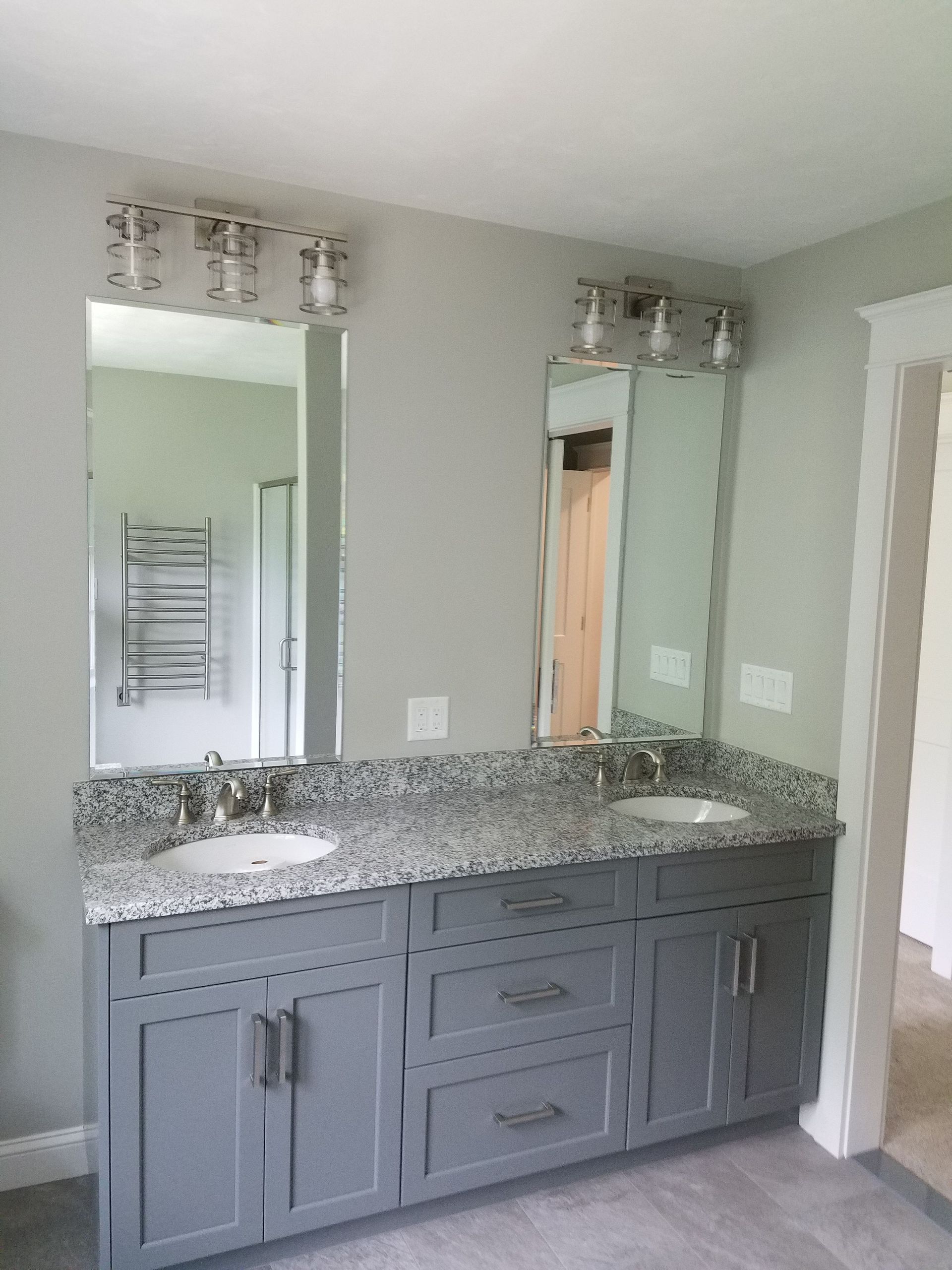 A bathroom with two sinks and a large mirror.