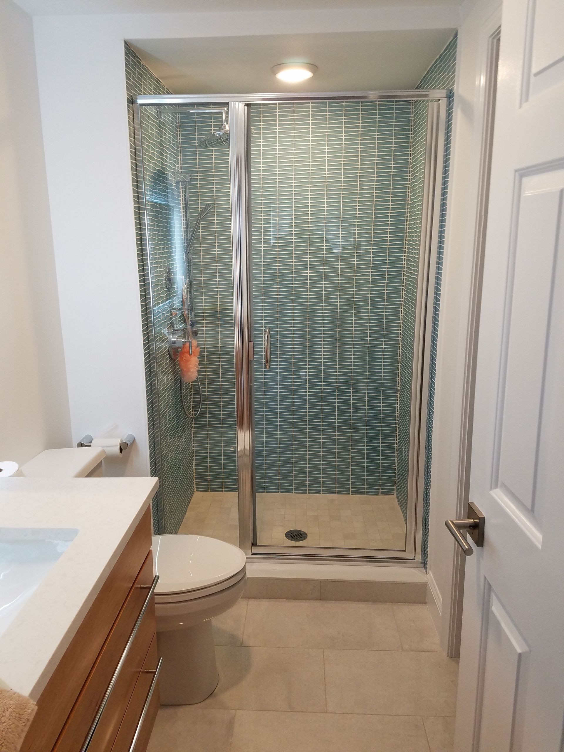 A bathroom with a toilet , sink and shower.