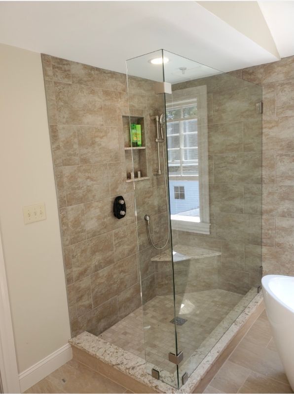 A bathroom with a walk in shower and a tub