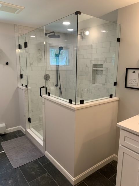 A bathroom with a walk in shower and a sink.