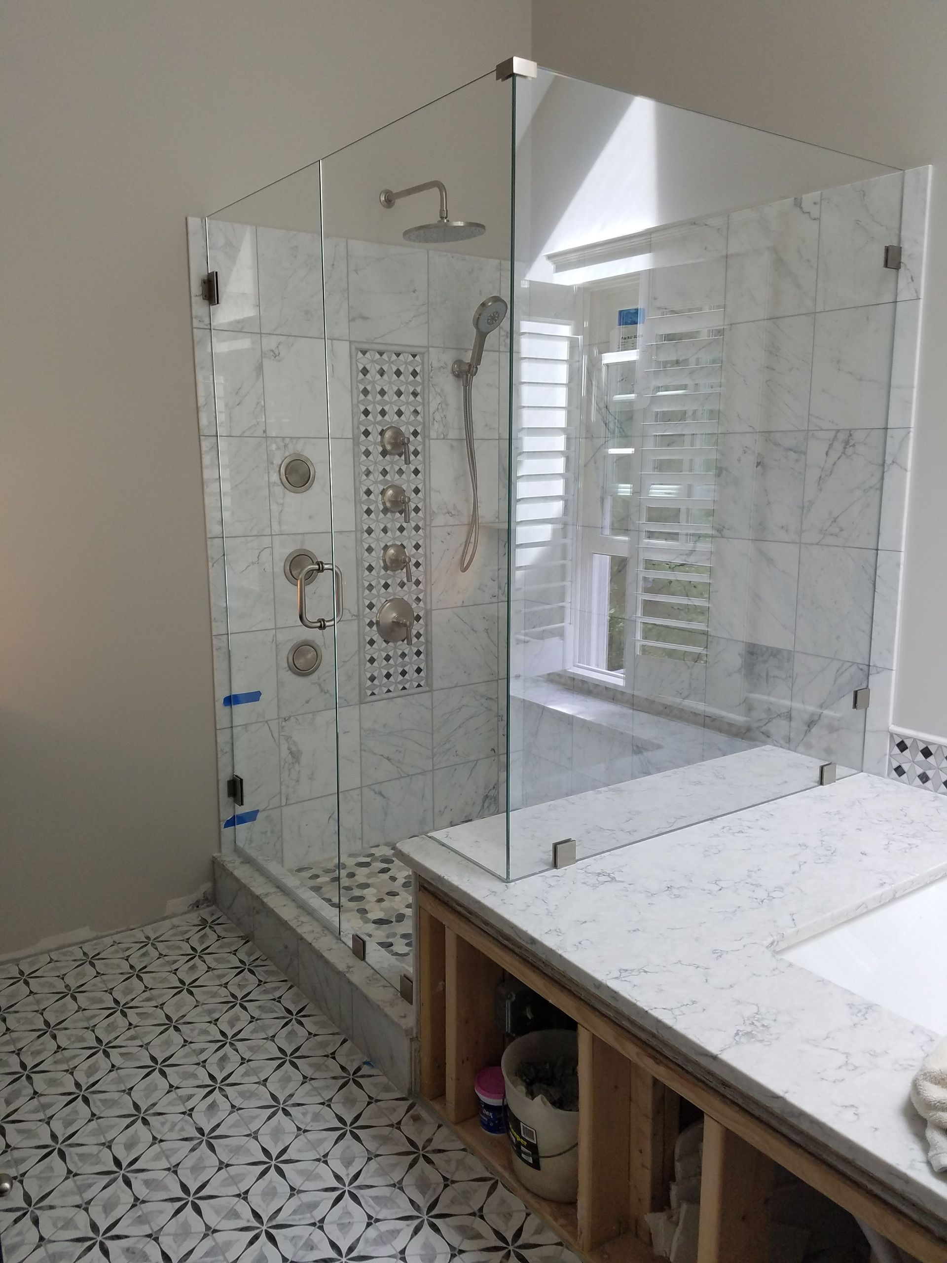 A bathroom with a walk in shower and a sink.